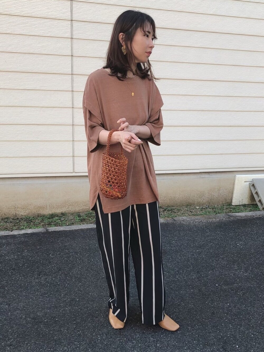 ブラウン系のTシャツ/カットソー、ブラウン系のハンドバッグ、ブラック系のその他パンツを着用したレディースの夏コーディネートの1枚目の写真