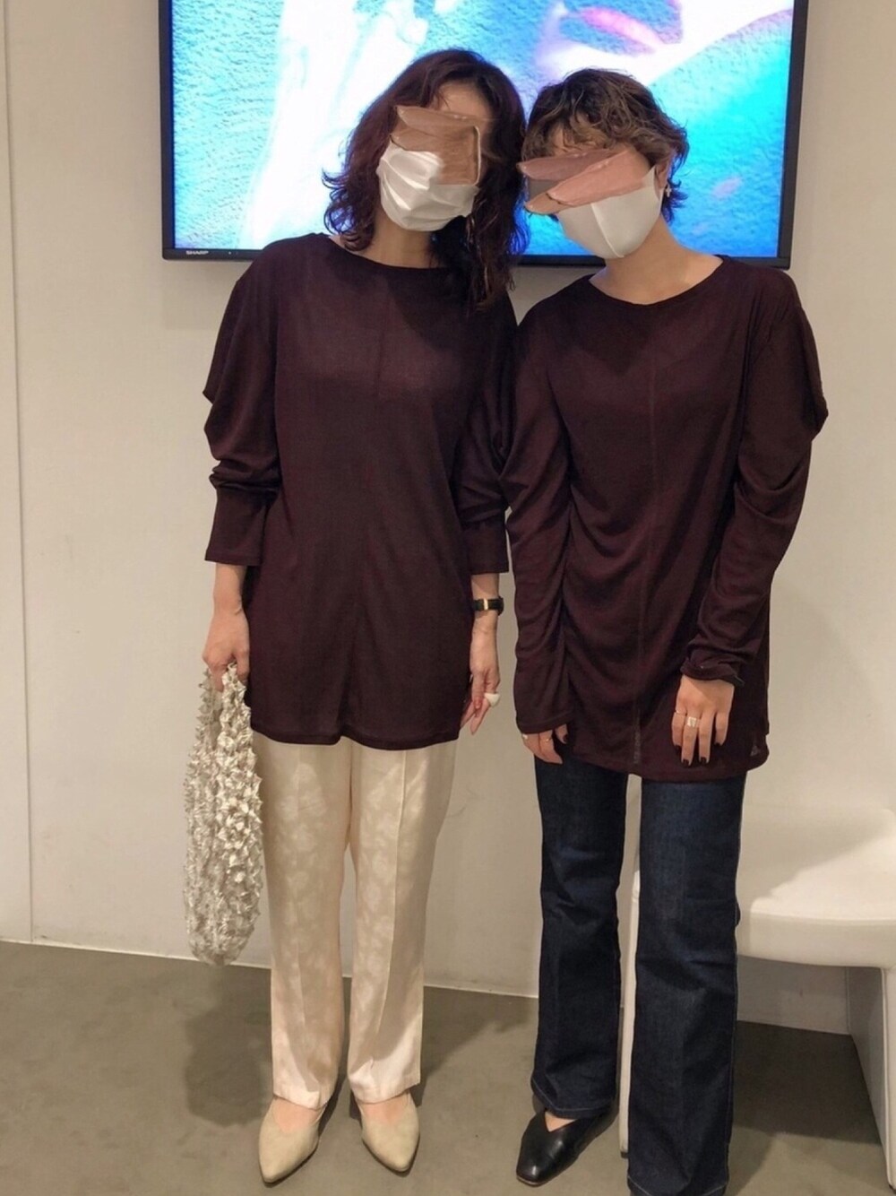 レッド系のTシャツ/カットソー、ホワイト系のその他パンツ、ベージュ系のハンドバッグを着用したレディースの秋コーディネートの1枚目の写真