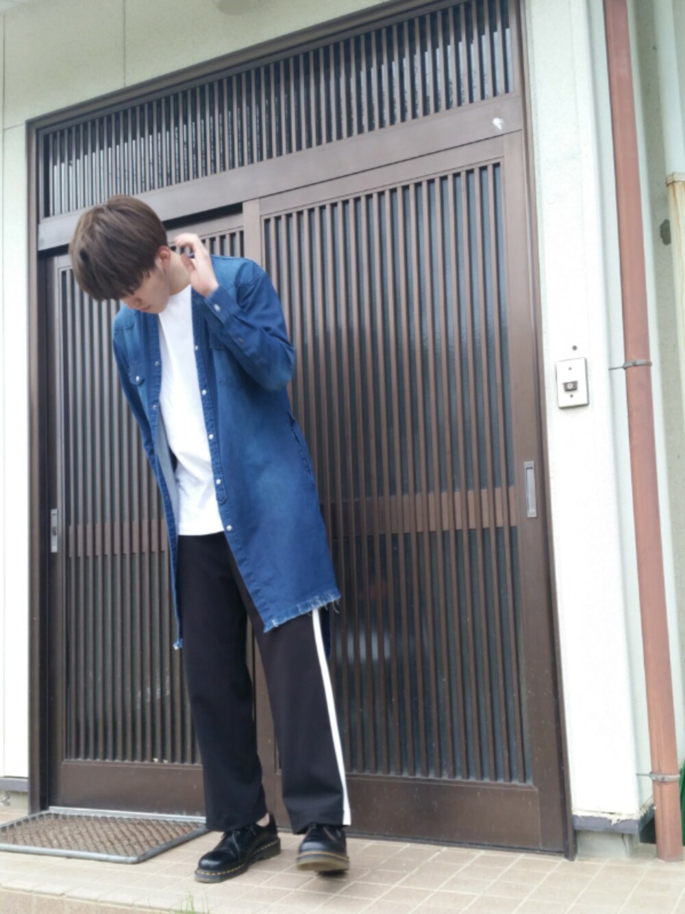 ホワイト系のTシャツ/カットソー、ブルー系のデニムジャケット、ブラック系のスラックスを着用したメンズの春コーディネートの1枚目の写真