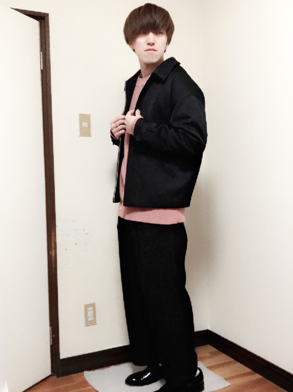 ブラック系のブルゾン、ピンク系のニット/セーター、ブラック系のスラックスを着用したメンズの冬コーディネートの1枚目の写真