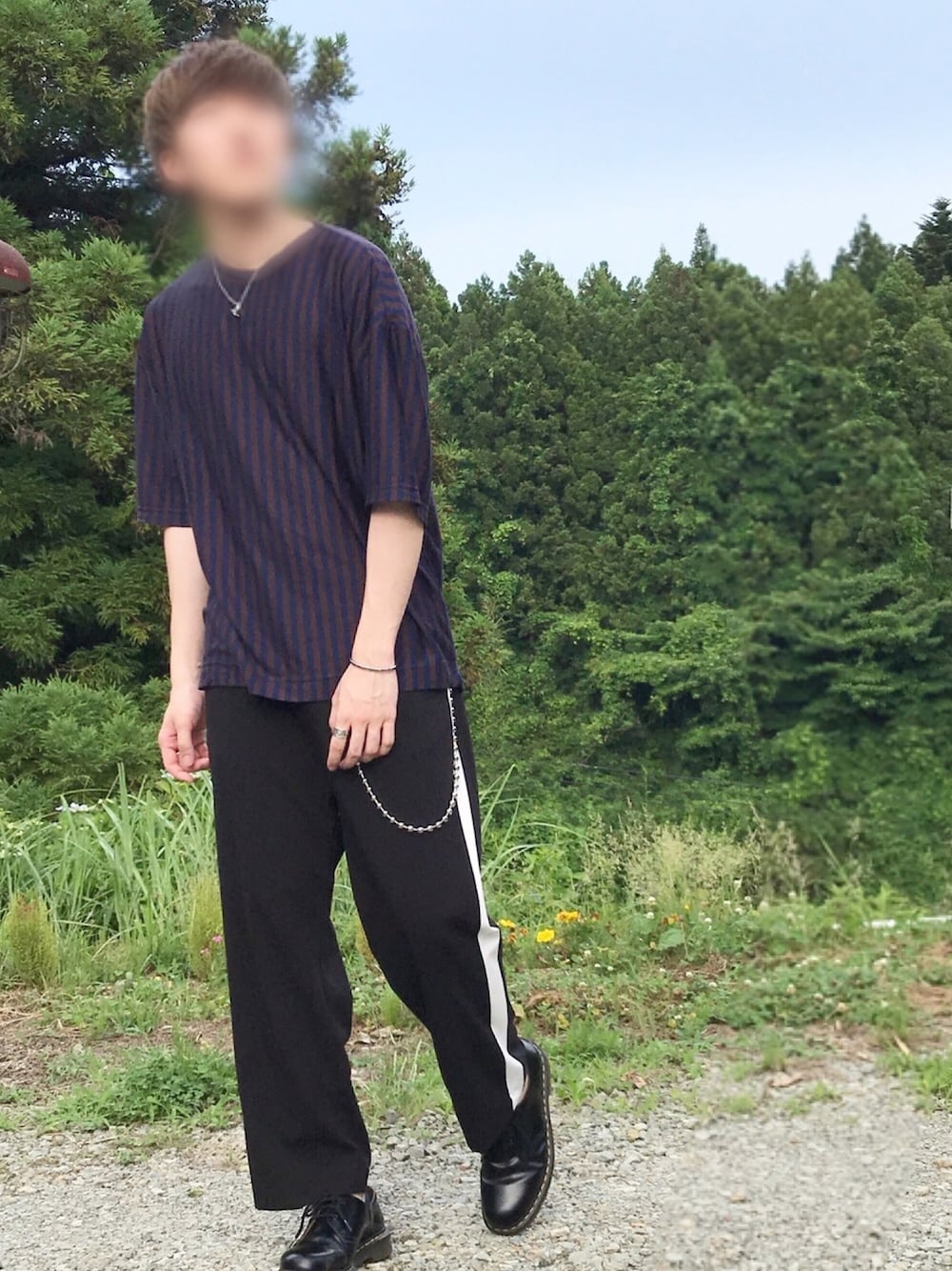 ブラウン系のTシャツ/カットソー、ブラック系のスラックス、ブラック系のブーツを着用したメンズの夏コーディネートの1枚目の写真