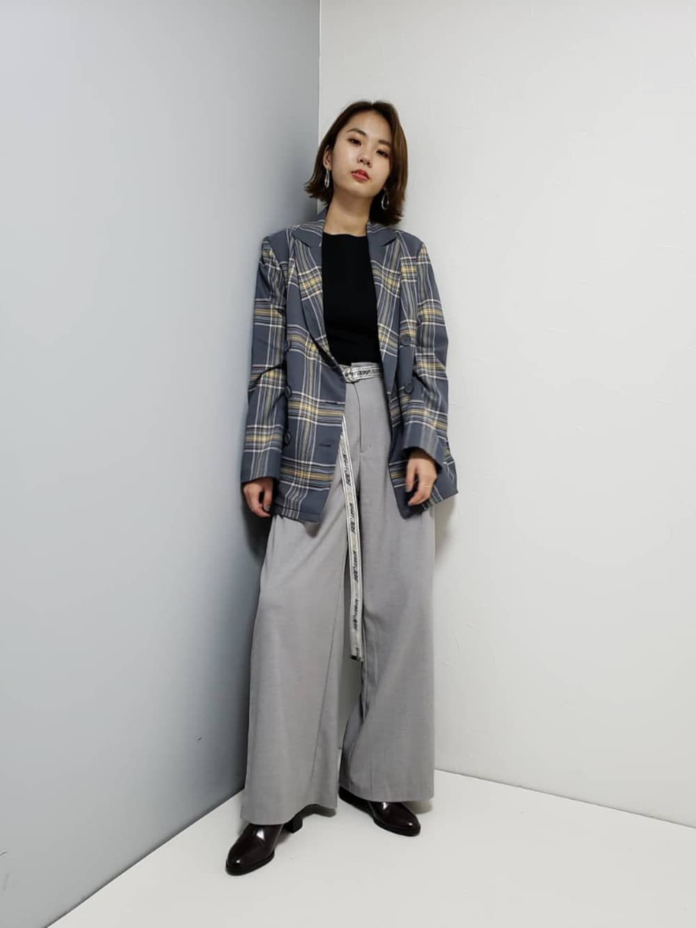 グレー系のテーラードジャケット、ブラック系のブーツ、グレー系のパンツを着用したレディースの冬コーディネートの1枚目の写真