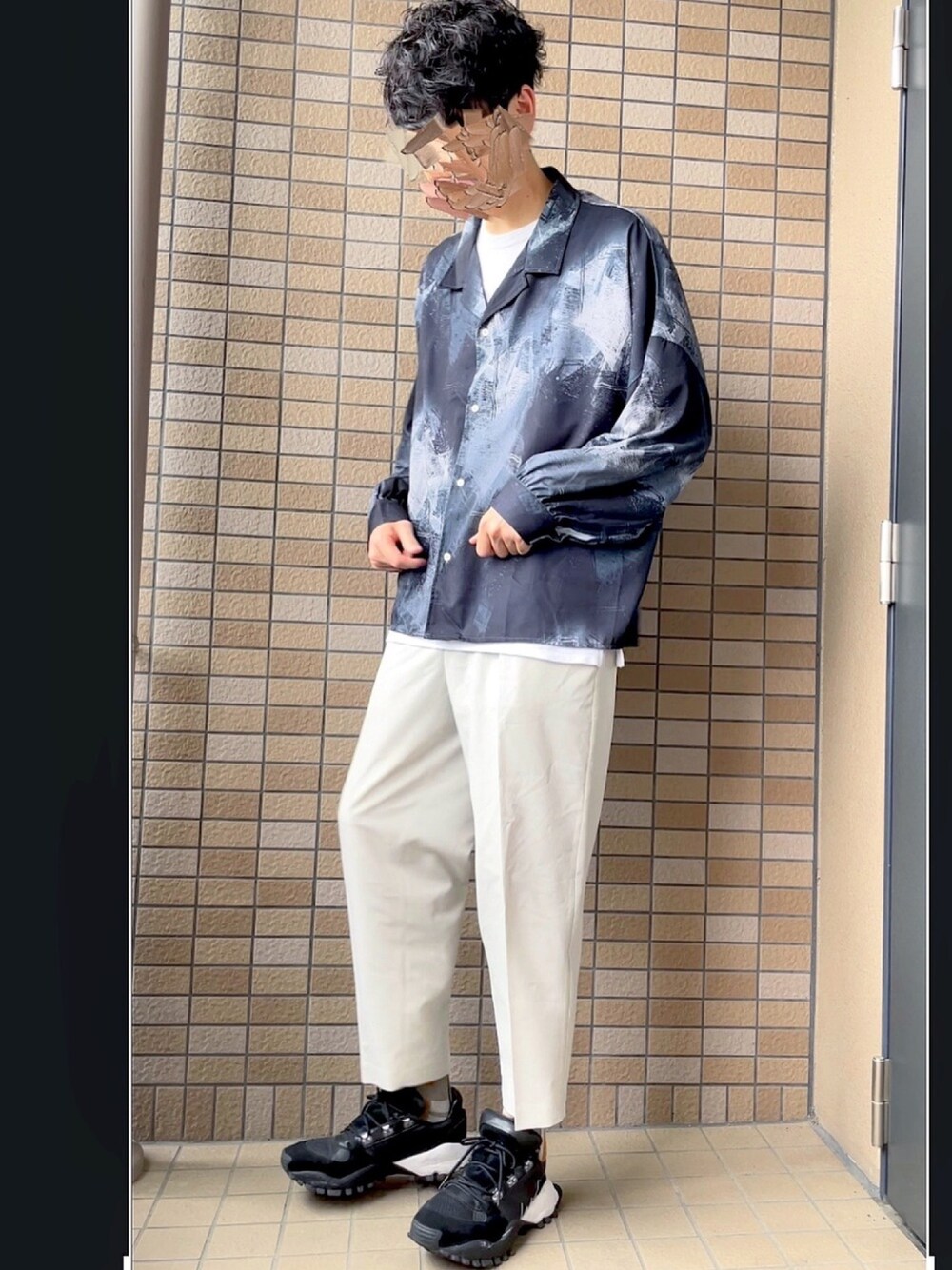 ブラック系のシャツ/ブラウス、ホワイト系のスラックス、ブラック系のスニーカーを着用したメンズの春コーディネートの1枚目の写真