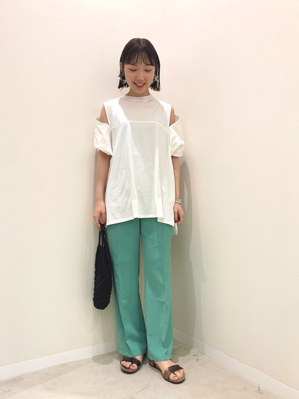 ホワイト系のTシャツ/カットソー、グリーン系のその他パンツ、ブラック系のハンドバッグを着用したレディースの夏コーディネートの1枚目の写真
