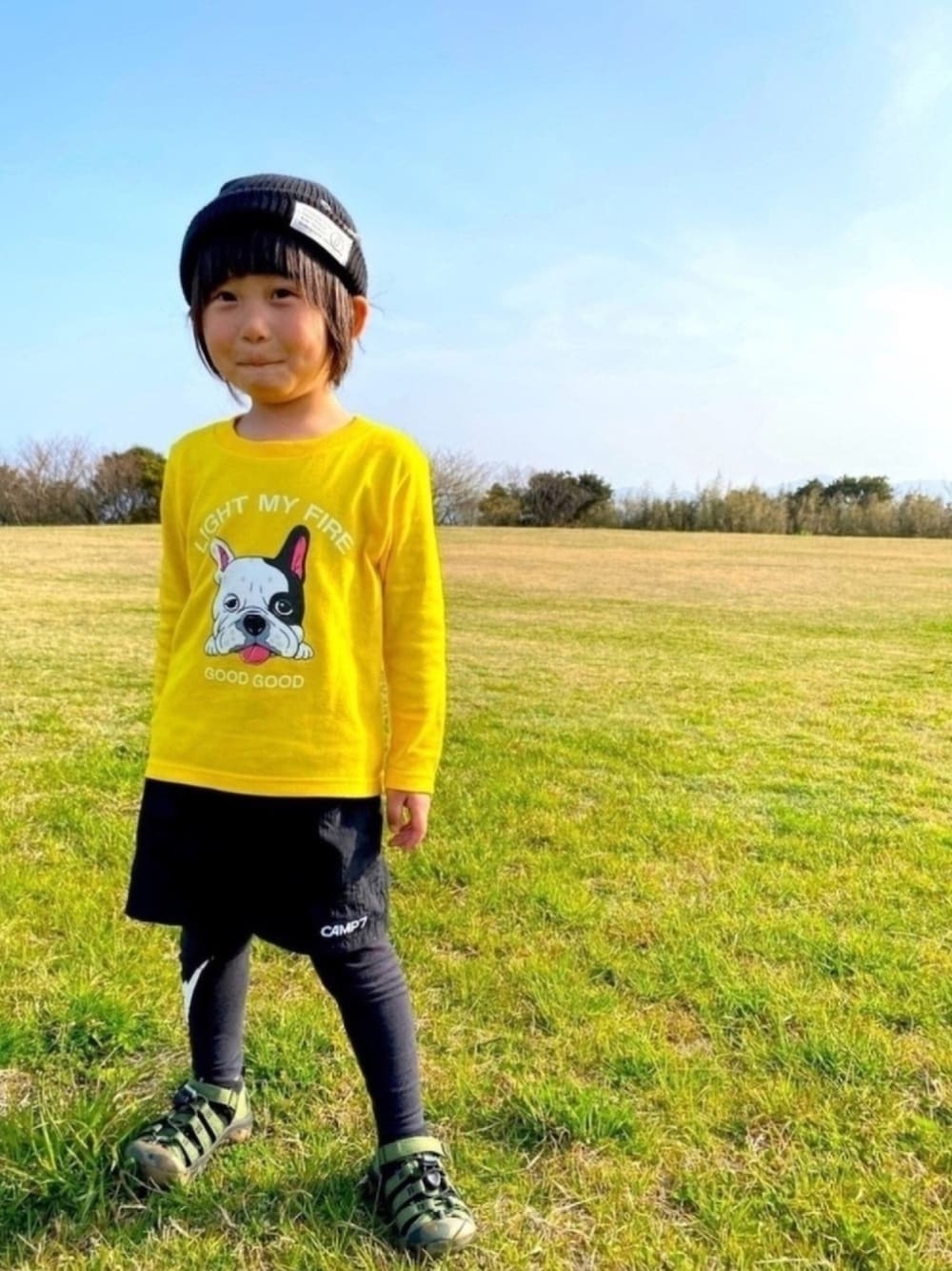 イエロー系のTシャツ/カットソー、ブラック系のパンツ、グリーン系のサンダルを着用したキッズの春コーディネートの1枚目の写真