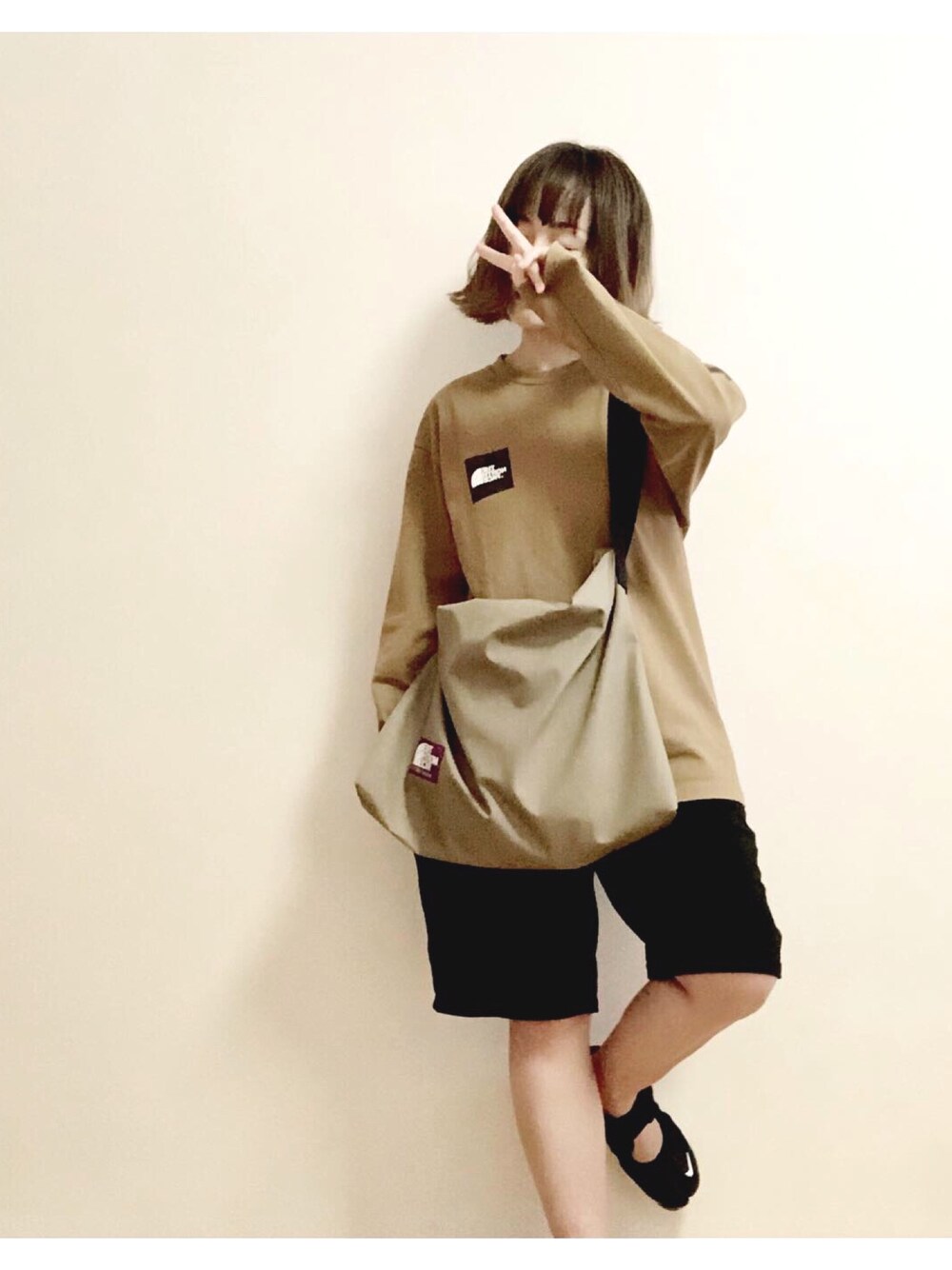 グリーン系のTシャツ/カットソー、ベージュ系のショルダーバッグを着用したレディースの秋コーディネートの1枚目の写真
