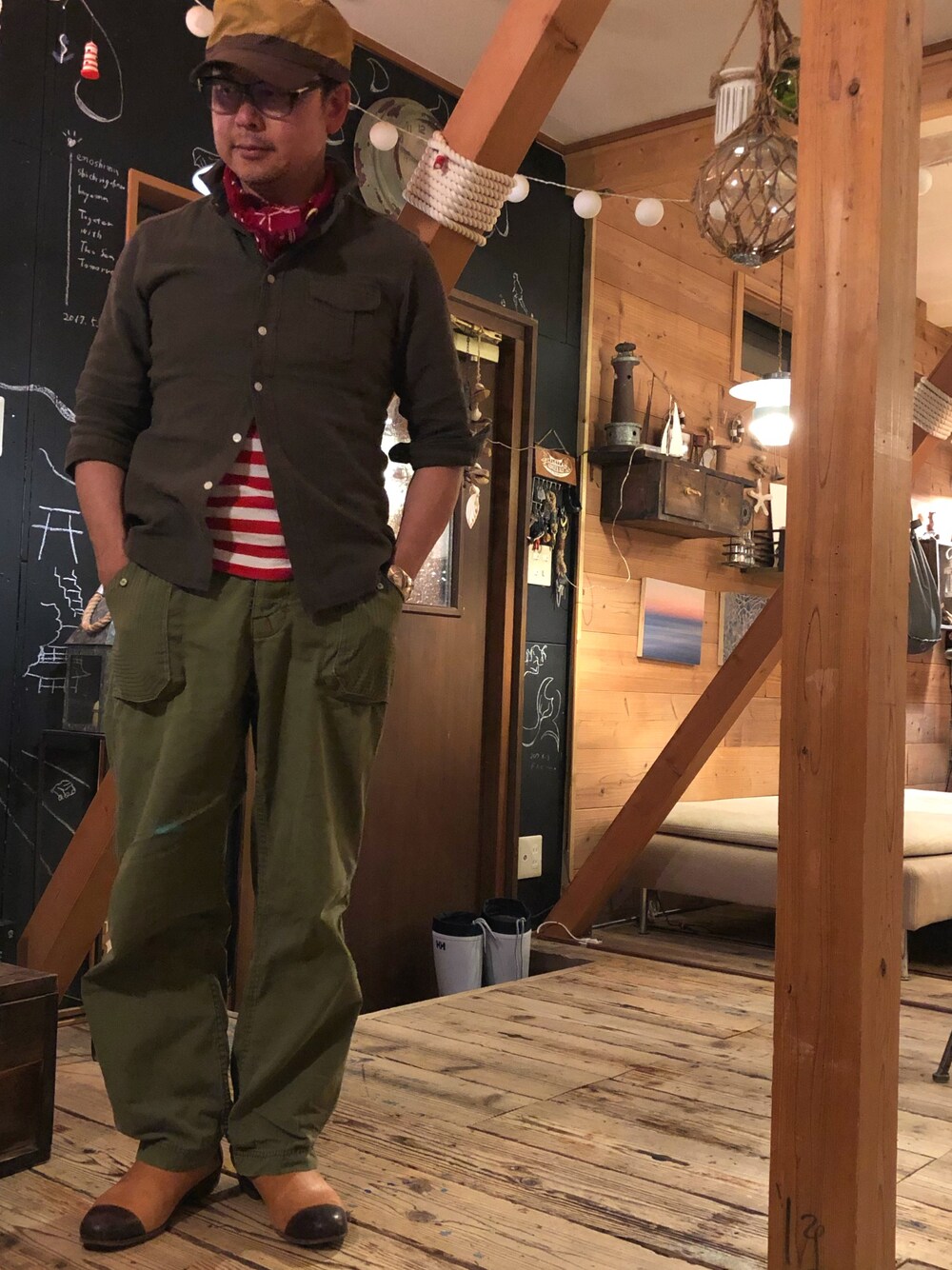 レッド系のTシャツ/カットソー、グリーン系のシャツ/ブラウス、グリーン系のカーゴパンツを着用したメンズの春コーディネートの1枚目の写真