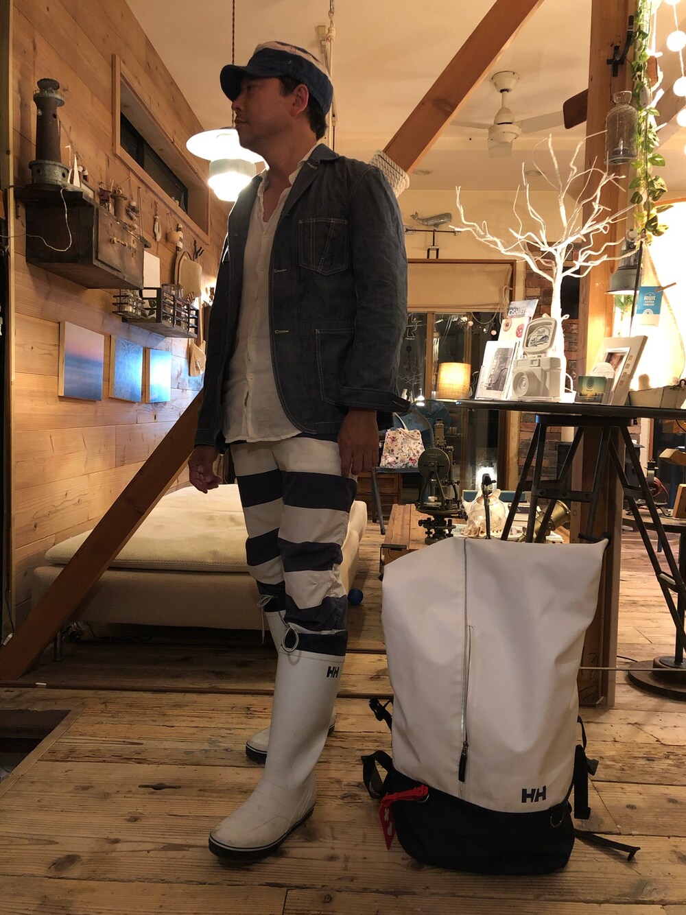 ブルー系のその他パンツ、ホワイト系のレインシューズ、ホワイト系のバックパック/リュックを着用したメンズの春コーディネートの1枚目の写真