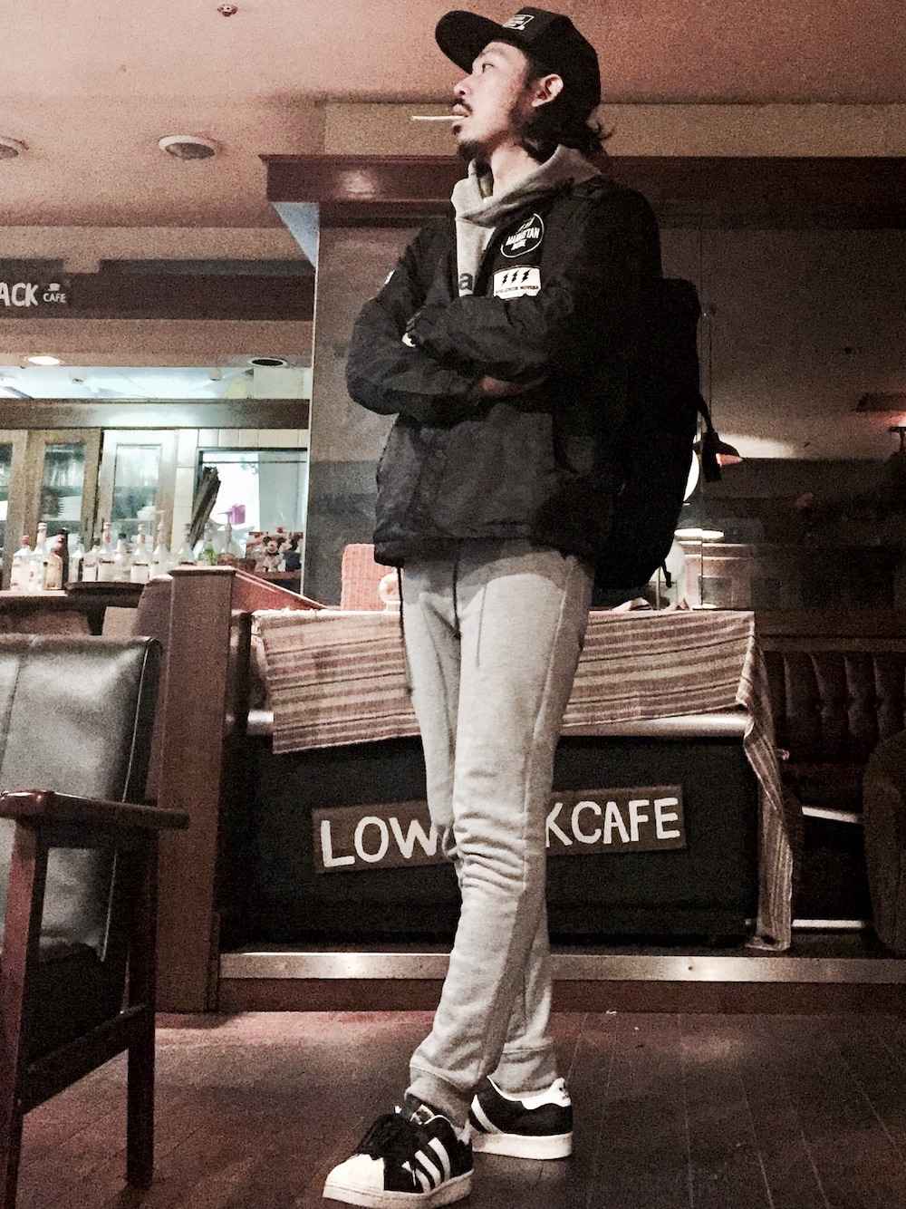 ブラック系のカバーオール、グレー系のパーカー、ブラック系のバックパック/リュックを着用したメンズの春コーディネートの1枚目の写真