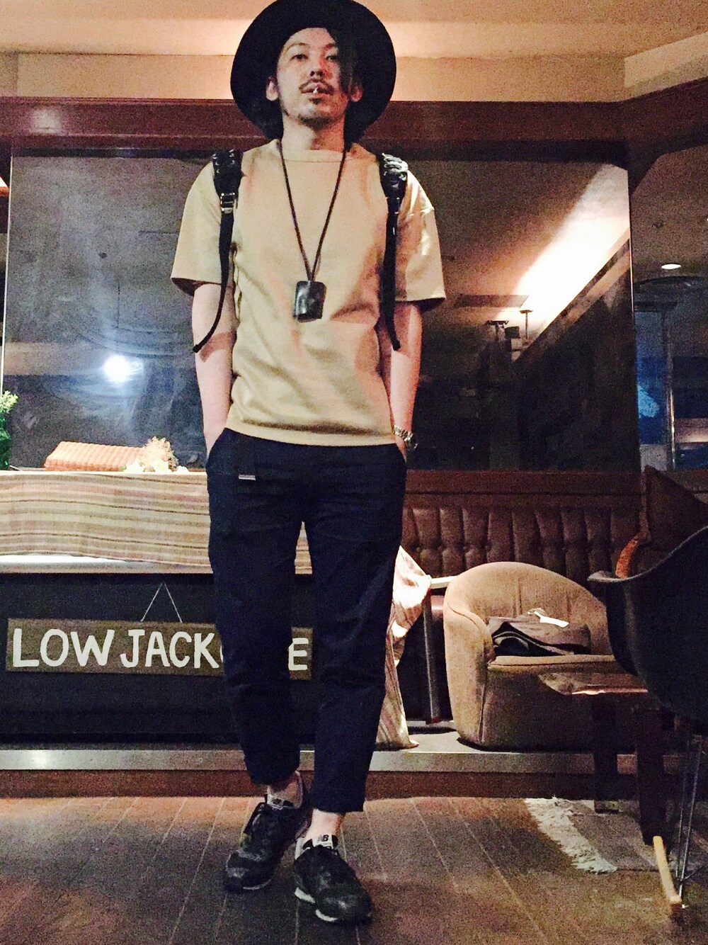 ベージュ系のTシャツ/カットソー、ブルー系のスラックス、ブラック系のスニーカーを着用したメンズの夏コーディネートの1枚目の写真