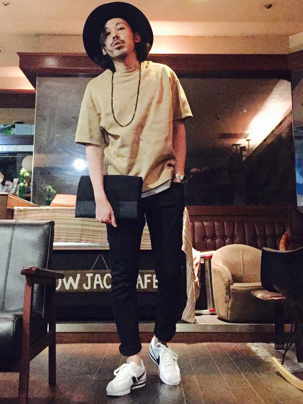 ベージュ系のTシャツ/カットソー、ブラック系のクラッチバッグ、ブラック系のチノパンツを着用したメンズの夏コーディネートの1枚目の写真