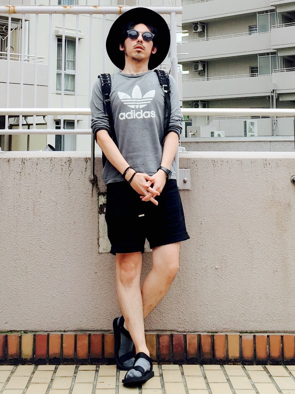 グレー系のTシャツ/カットソー、ブラック系のデニムパンツ、ブラック系のサンダルを着用したメンズの夏コーディネートの1枚目の写真