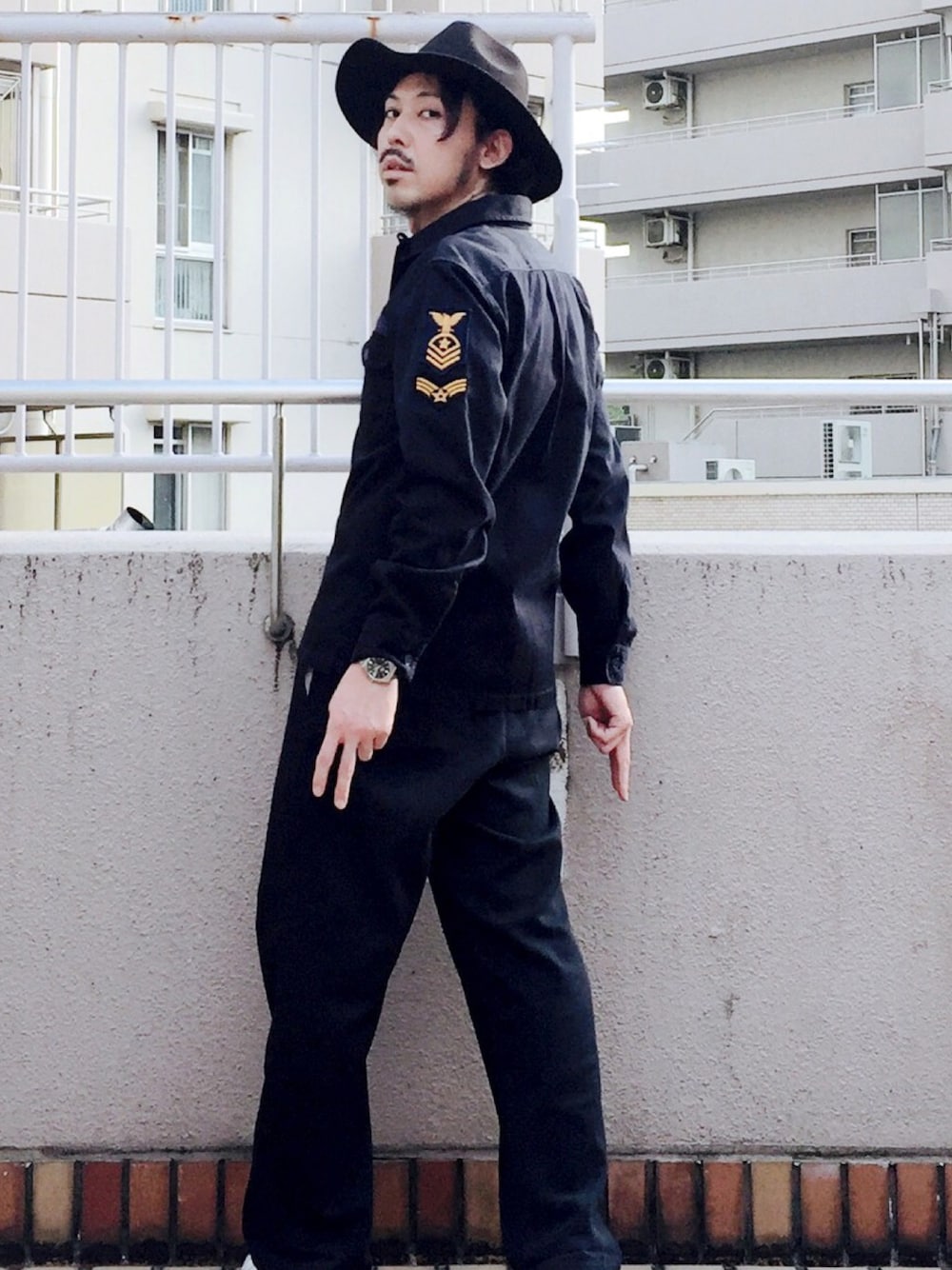 ブルー系のシャツ/ブラウス、ブラック系のチノパンツ、ホワイト系のスニーカーを着用したメンズの秋コーディネートの1枚目の写真