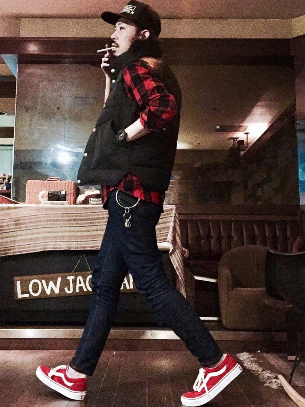 ブラック系のダウンベスト、レッド系のシャツ/ブラウス、ブルー系のデニムパンツを着用したメンズの春コーディネートの1枚目の写真