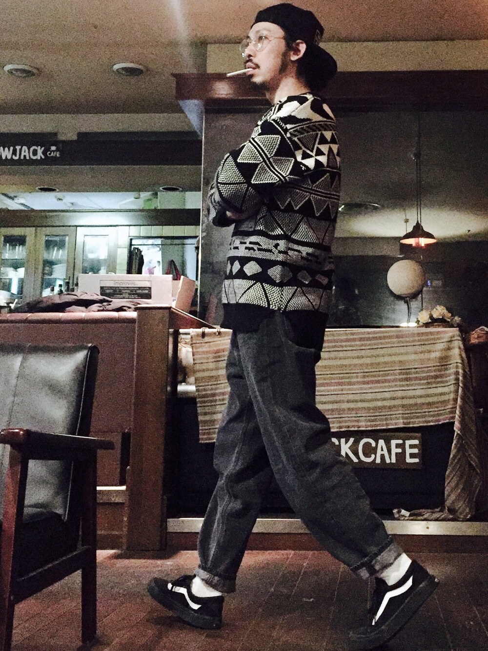 ブラック系のニット/セーター、ブラック系のデニムパンツ、ブラック系のスニーカーを着用したメンズの冬コーディネートの1枚目の写真