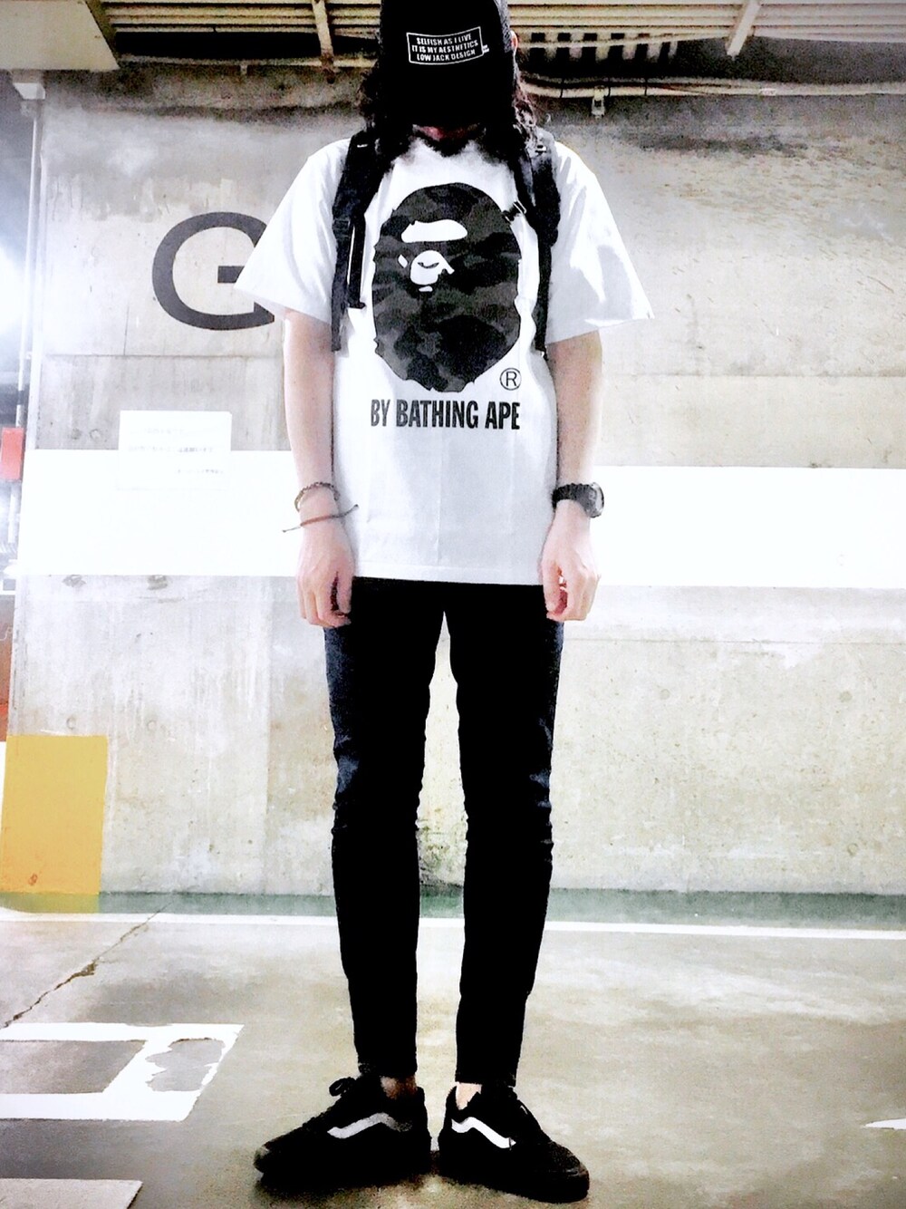 ブラック系のスニーカー、ホワイト系のTシャツ/カットソー、ブラック系のデニムパンツを着用したメンズの春コーディネートの1枚目の写真