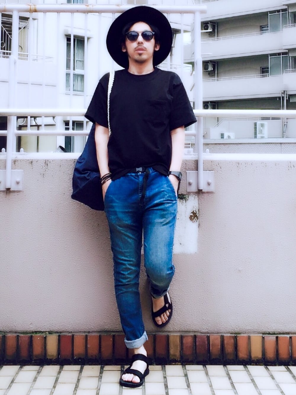 ブラック系のTシャツ/カットソー、ブルー系のデニムパンツ、ブルー系のバックパック/リュックを着用したメンズの夏コーディネートの1枚目の写真