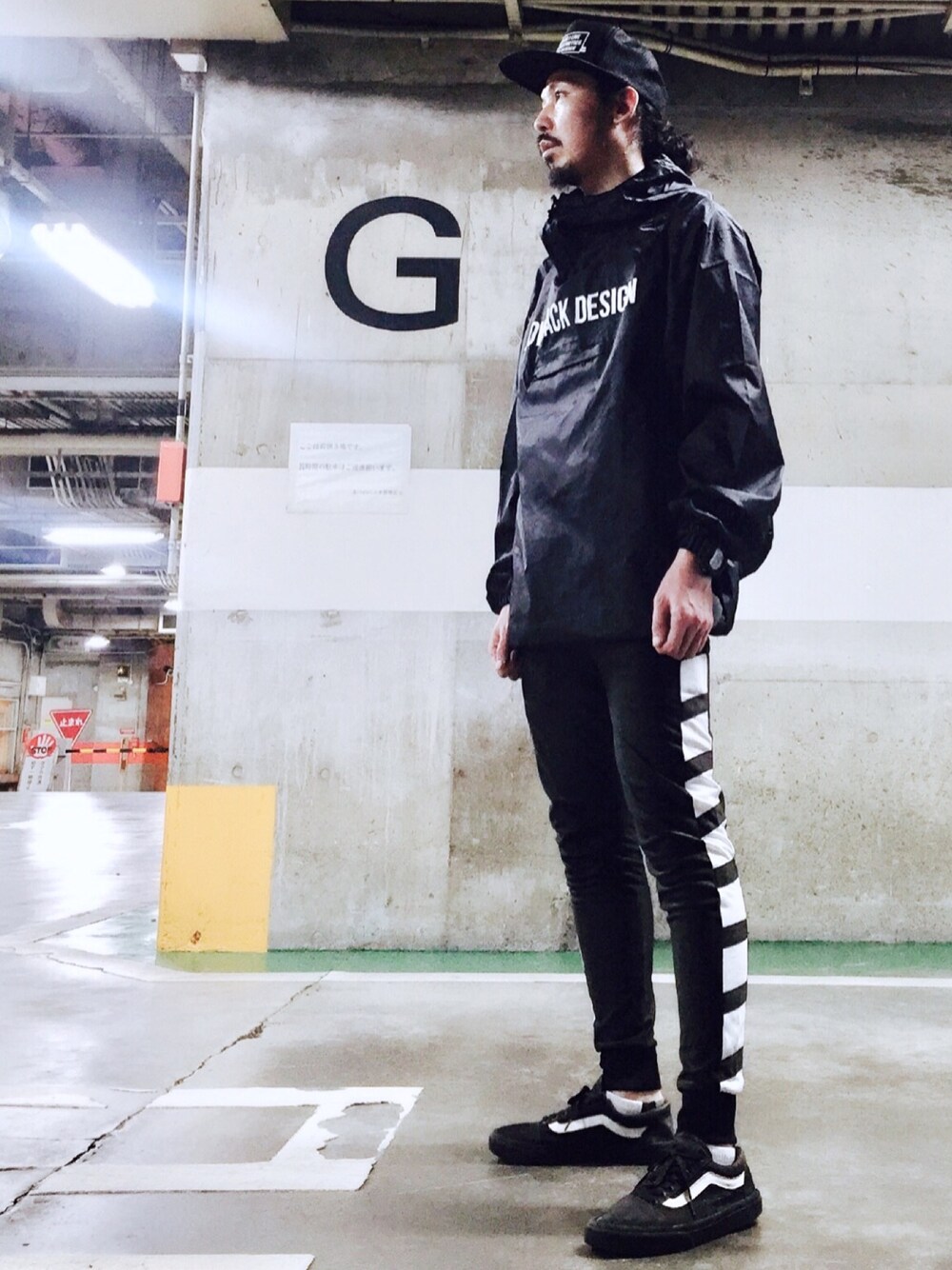 ブラック系のナイロンジャケット、ブラック系のその他パンツ、ブラック系のスニーカーを着用したメンズの秋コーディネートの1枚目の写真