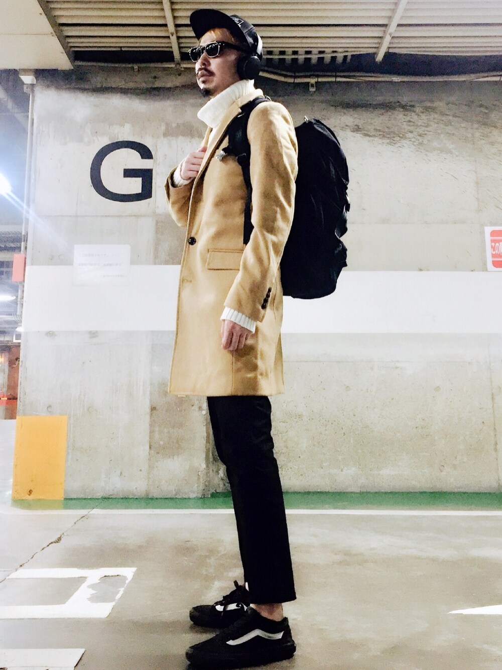 ベージュ系のチェスターコート、ホワイト系のニット/セーター、ブラック系のチノパンツを着用したメンズの秋コーディネートの1枚目の写真