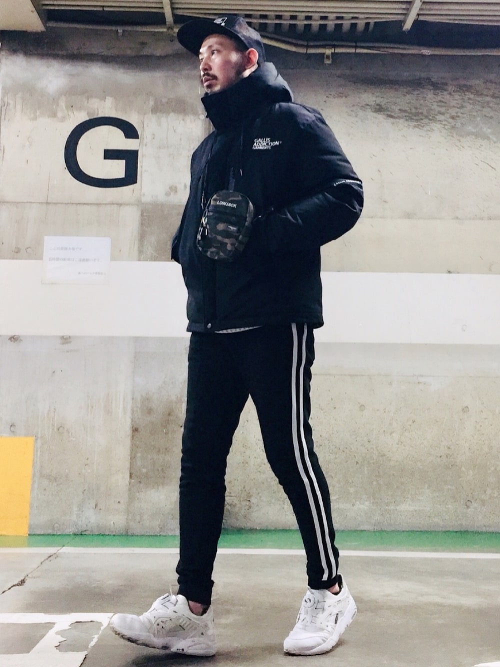 ブラック系のショルダーバッグ、ブラック系のダウンジャケット/コート、ブラック系のスウェットパンツを着用したメンズの冬コーディネートの1枚目の写真