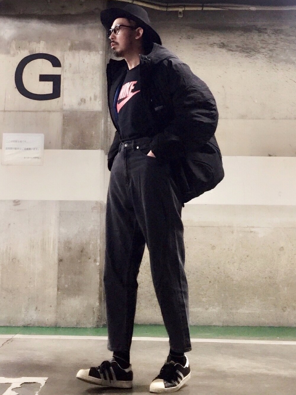 ブラック系のダウンジャケット/コート、ブラック系のTシャツ/カットソー、ブラック系のデニムパンツを着用したメンズの冬コーディネートの1枚目の写真