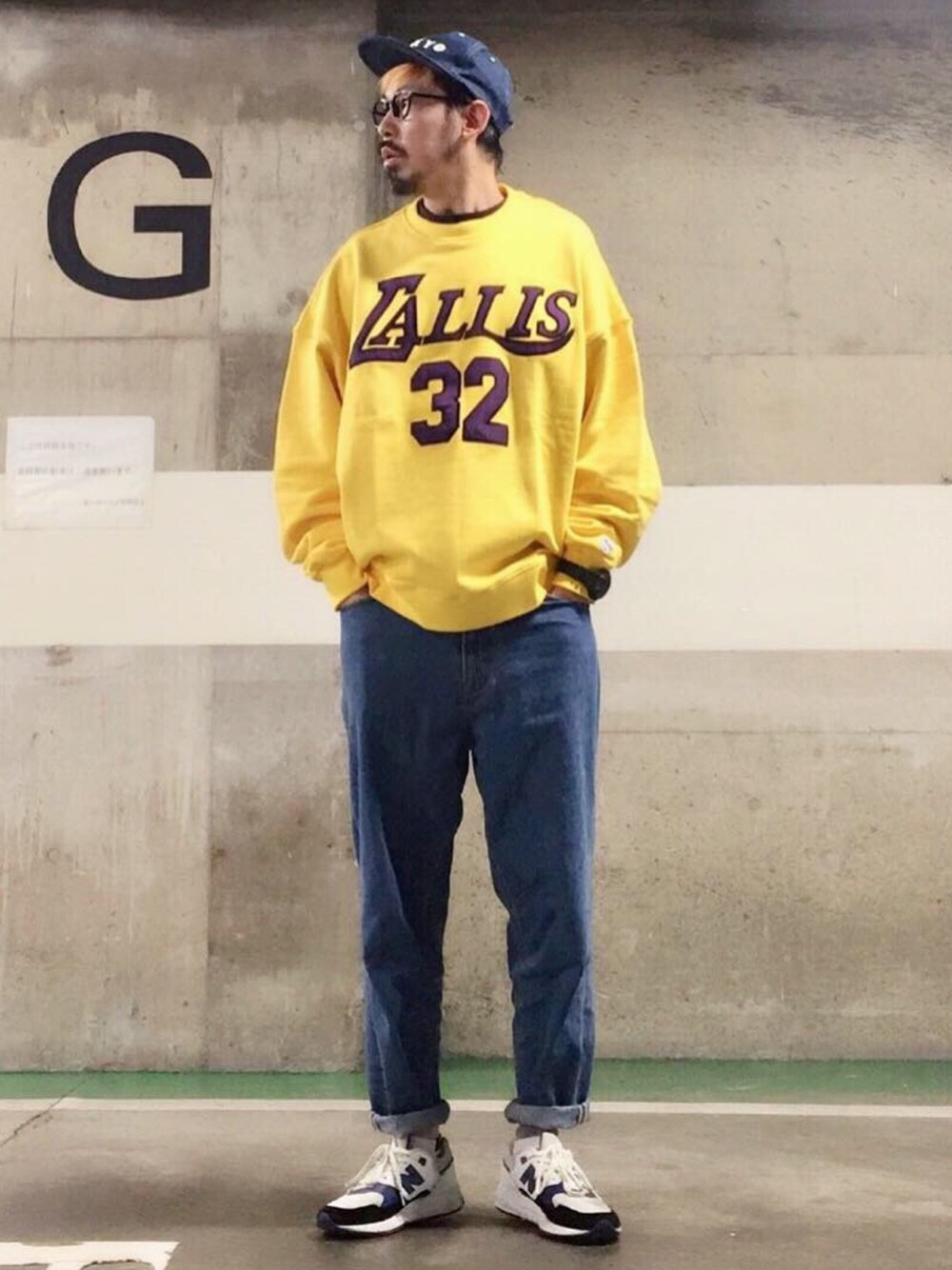 イエロー系のスウェット、ブルー系のデニムパンツ、ホワイト系のスニーカーを着用したメンズの春コーディネートの1枚目の写真