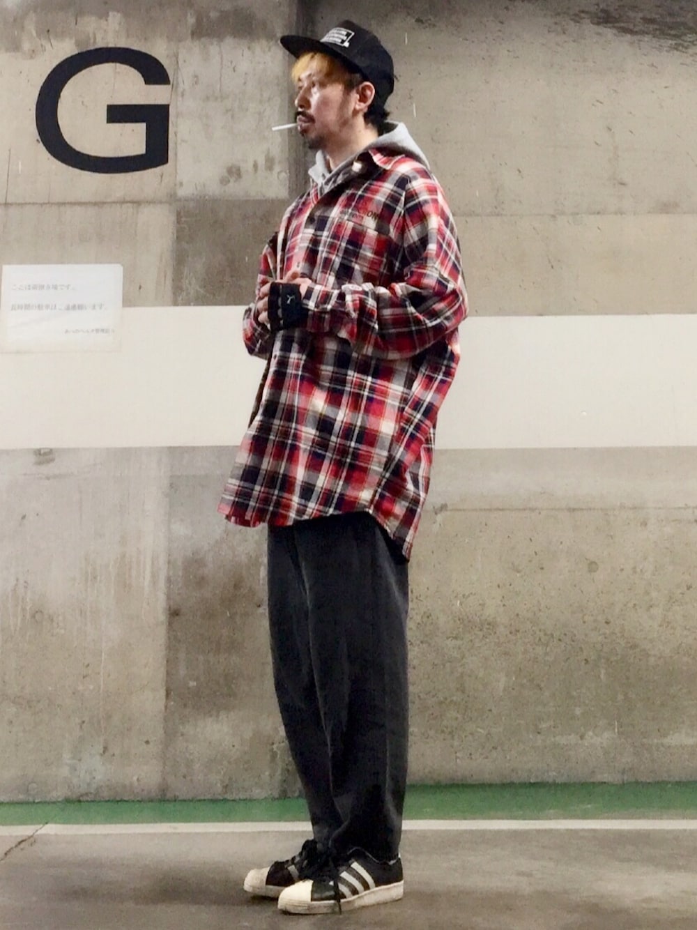 グレー系のパーカー、ブラック系のデニムパンツ、ブラック系のスニーカーを着用したメンズの春コーディネートの1枚目の写真