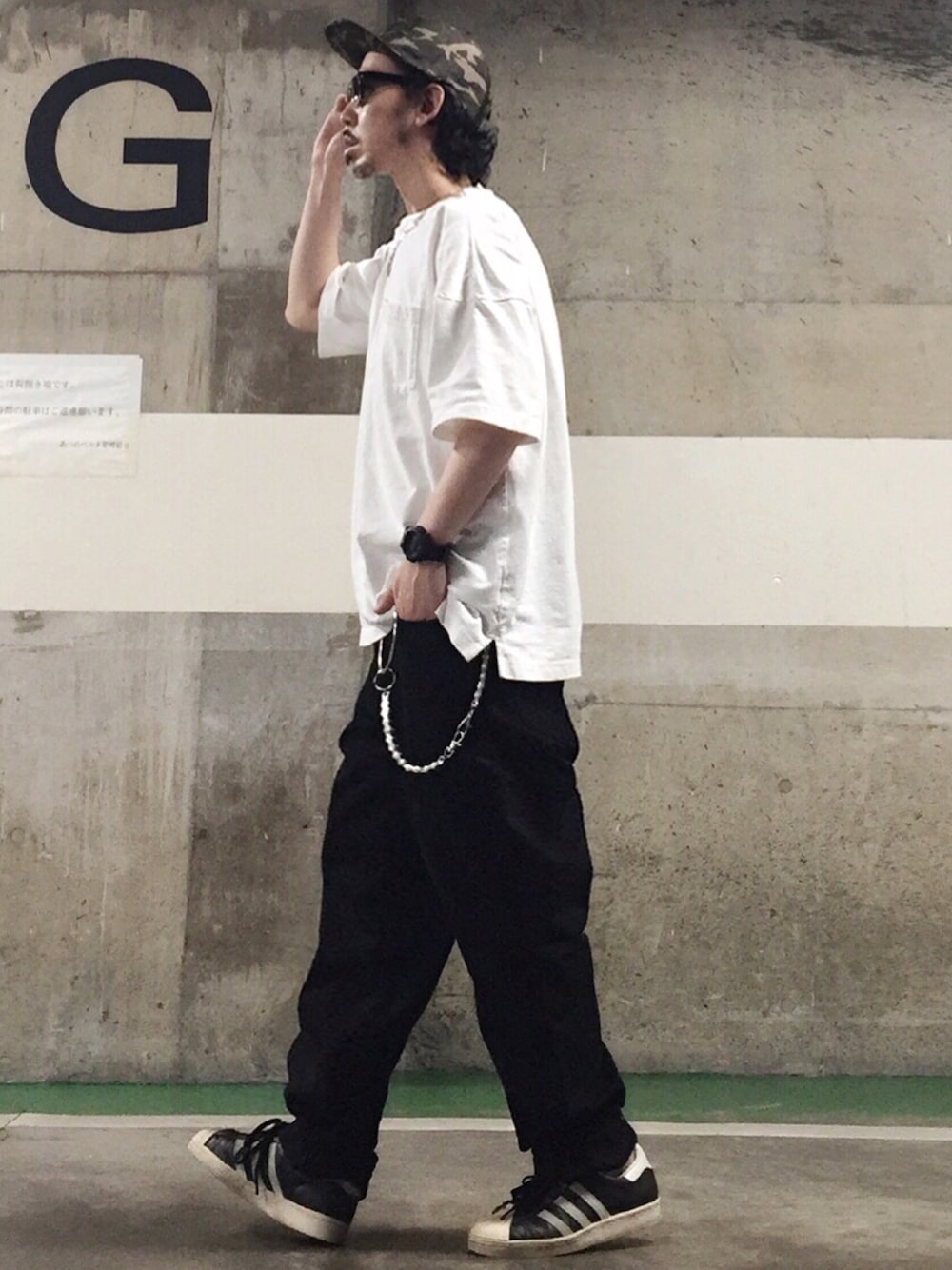 ブラック系のスニーカー、ブラック系のデニムパンツ、その他のキャップを着用したメンズの夏コーディネートの1枚目の写真