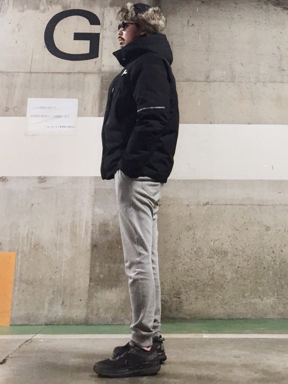 ブラック系のダウンジャケット/コート、ブラック系のスニーカー、グレー系のスウェットパンツを着用したメンズの冬コーディネートの1枚目の写真