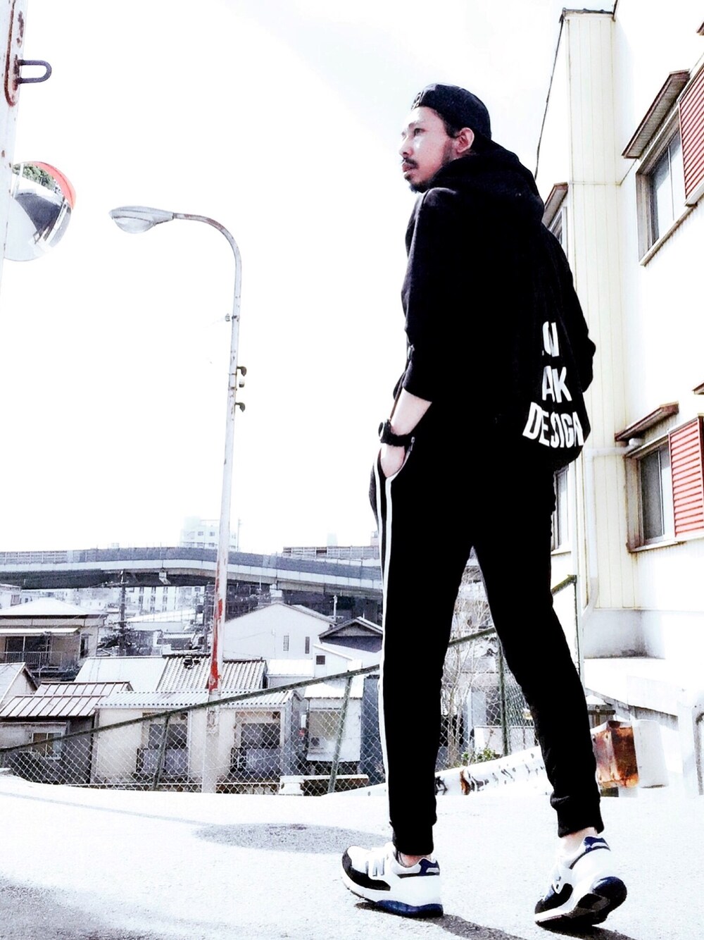 ブラック系のスウェットパンツ、ホワイト系のスニーカー、ブラック系のパーカーを着用したメンズの冬コーディネートの1枚目の写真