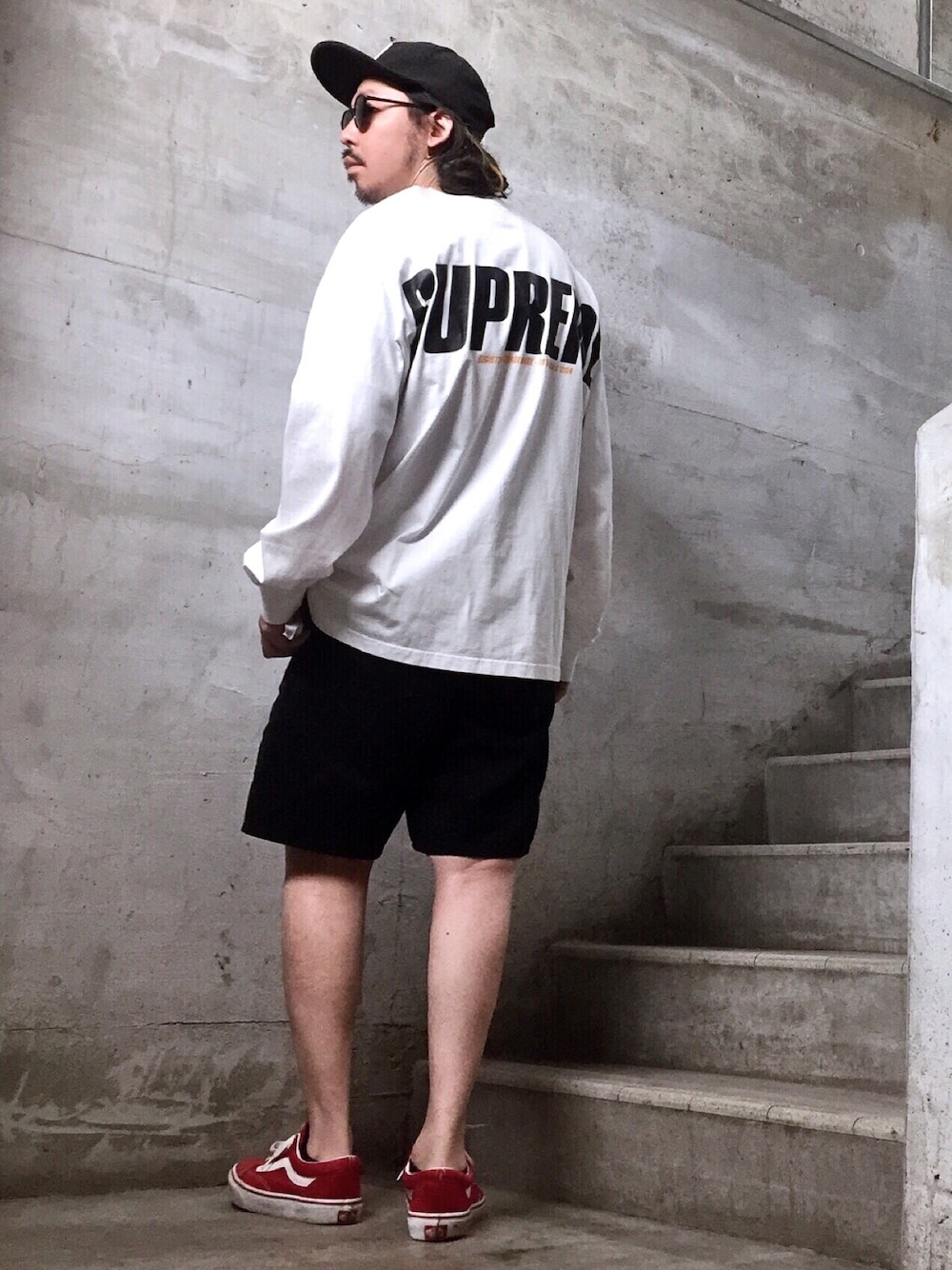 ホワイト系のTシャツ/カットソー、レッド系のスニーカー、ブラック系のその他パンツを着用したメンズの春コーディネートの1枚目の写真