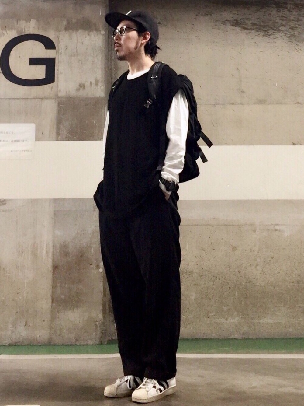 ブラック系のベスト、ホワイト系のスニーカー、ブラック系のその他パンツを着用したメンズの夏コーディネートの1枚目の写真