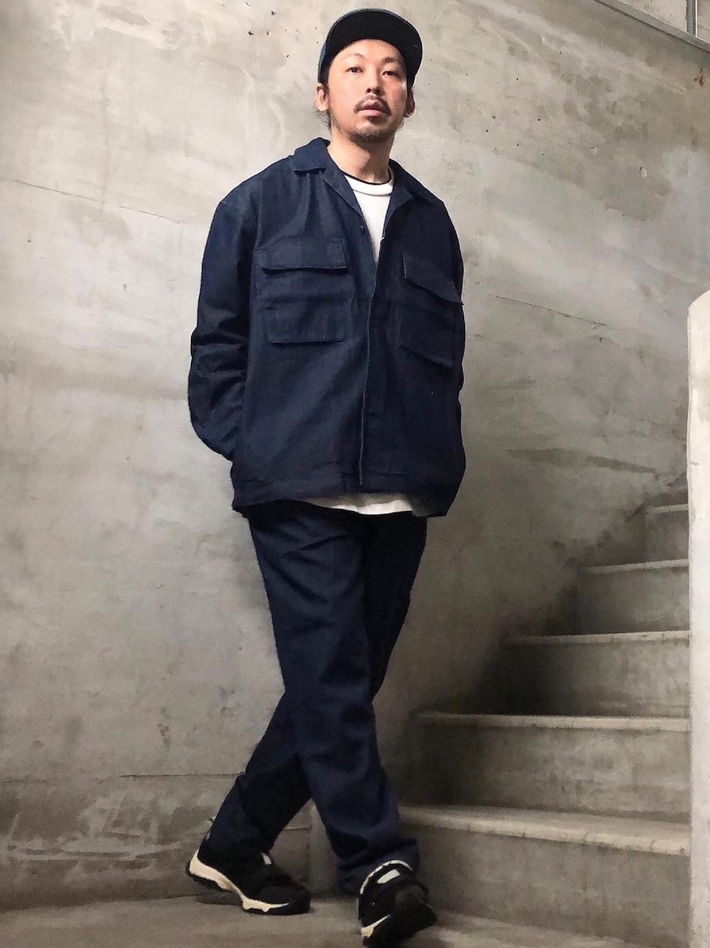 ブルー系のセットアップ、ブラック系のスニーカー、ホワイト系のTシャツ/カットソーを着用したメンズの秋コーディネートの1枚目の写真