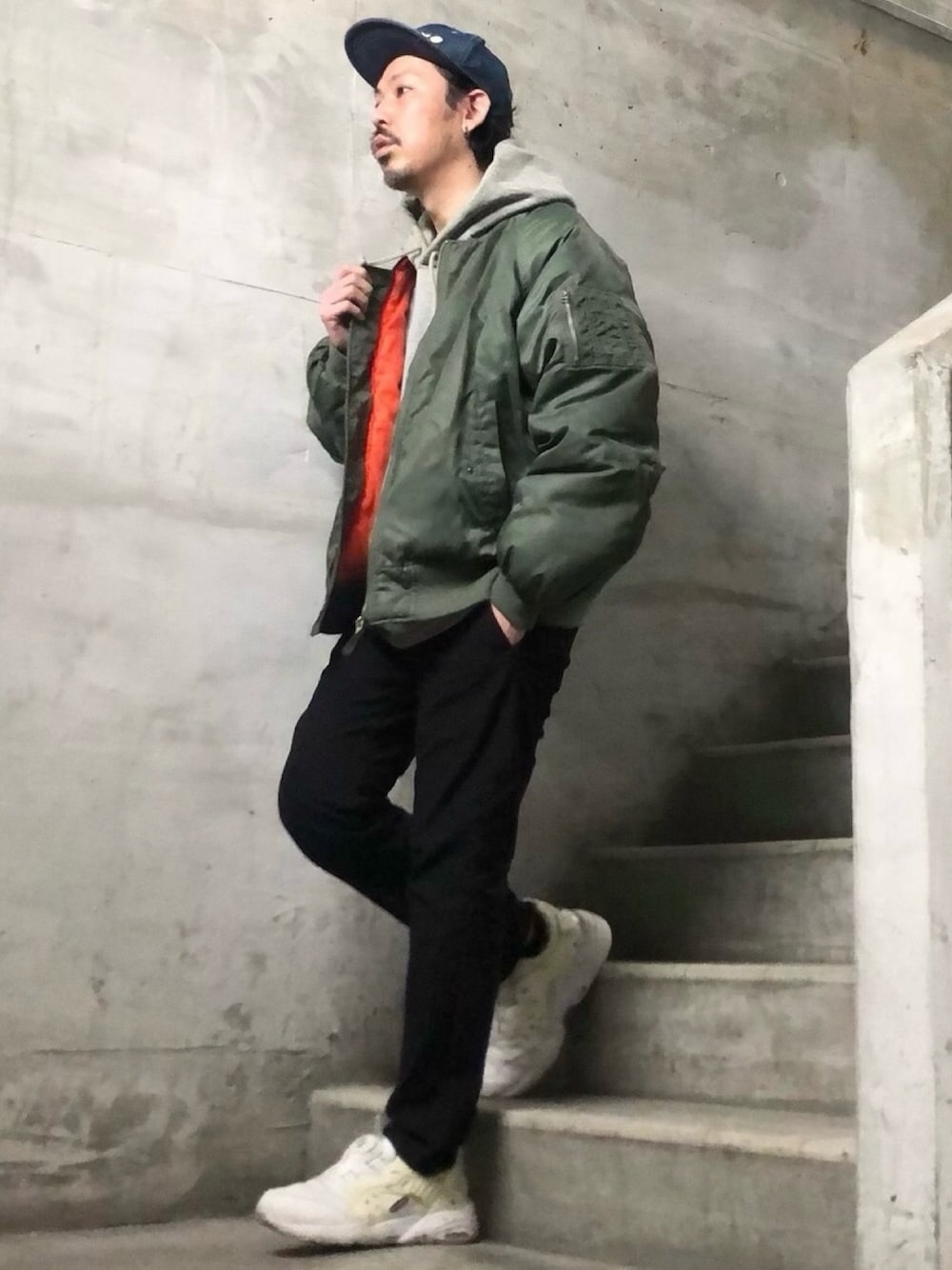 ホワイト系のスニーカー、ブラック系のチノパンツ、グレー系のパーカーを着用したメンズの秋コーディネートの1枚目の写真