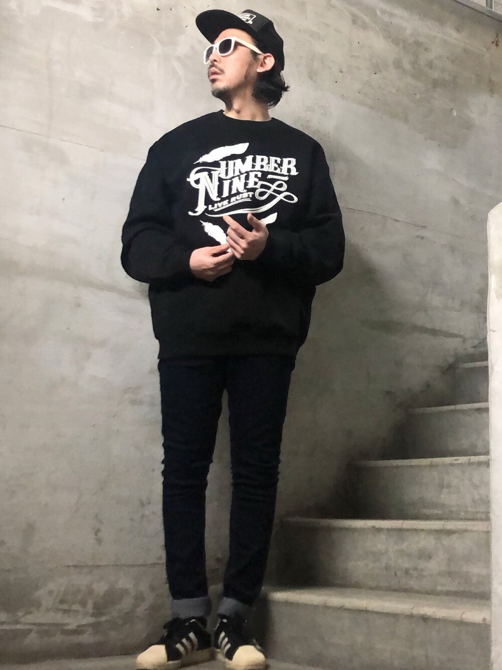 ブラック系のスウェット、ブルー系のデニムパンツ、ブラック系のスニーカーを着用したメンズの冬コーディネートの1枚目の写真
