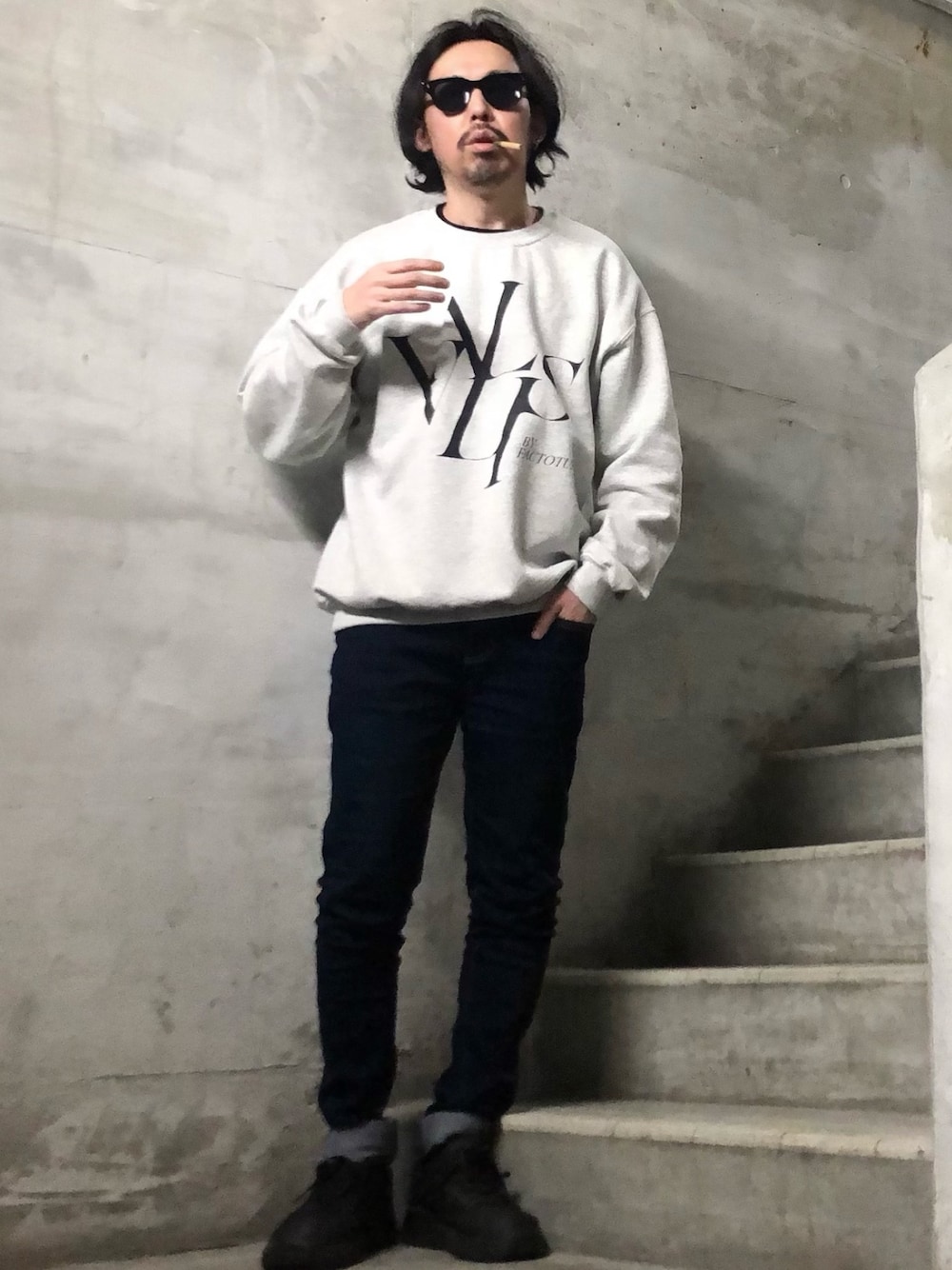 グレー系のスウェット、ブルー系のデニムパンツ、ブラック系のサングラスを着用したメンズの春コーディネートの1枚目の写真