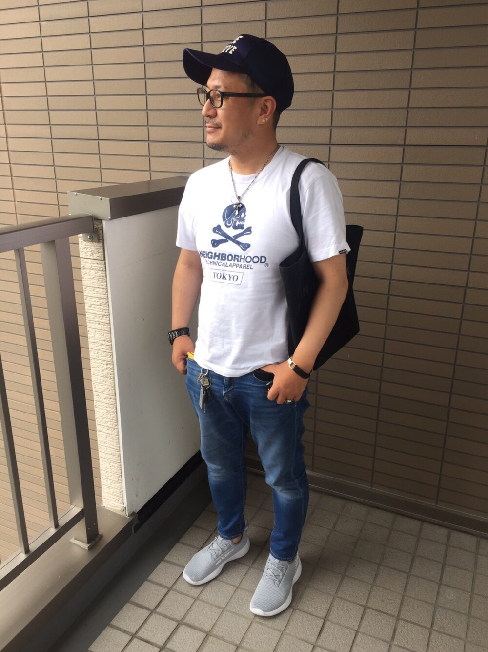 ホワイト系のTシャツ/カットソー、ブルー系のデニムパンツ、グレー系のスニーカーを着用したメンズの秋コーディネートの1枚目の写真