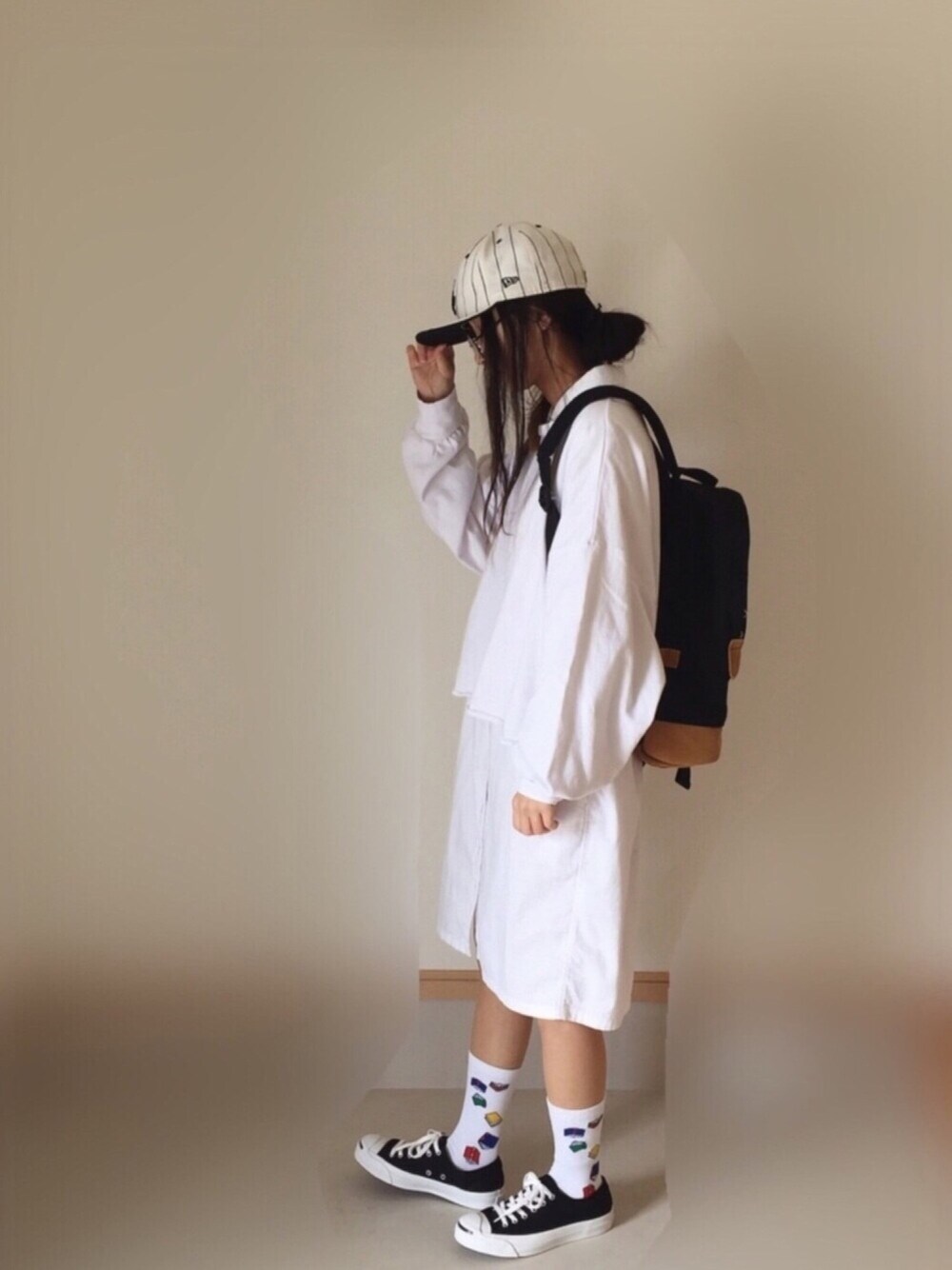 ホワイト系のシャツワンピース、ホワイト系のTシャツ/カットソー、ブラック系のスニーカーを着用したレディースの春コーディネートの1枚目の写真