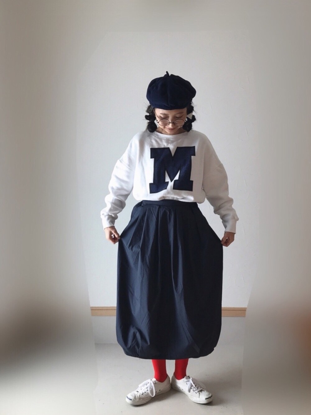 ホワイト系のスウェット、ブルー系のスカート、ホワイト系のスニーカーを着用したレディースの秋コーディネートの1枚目の写真