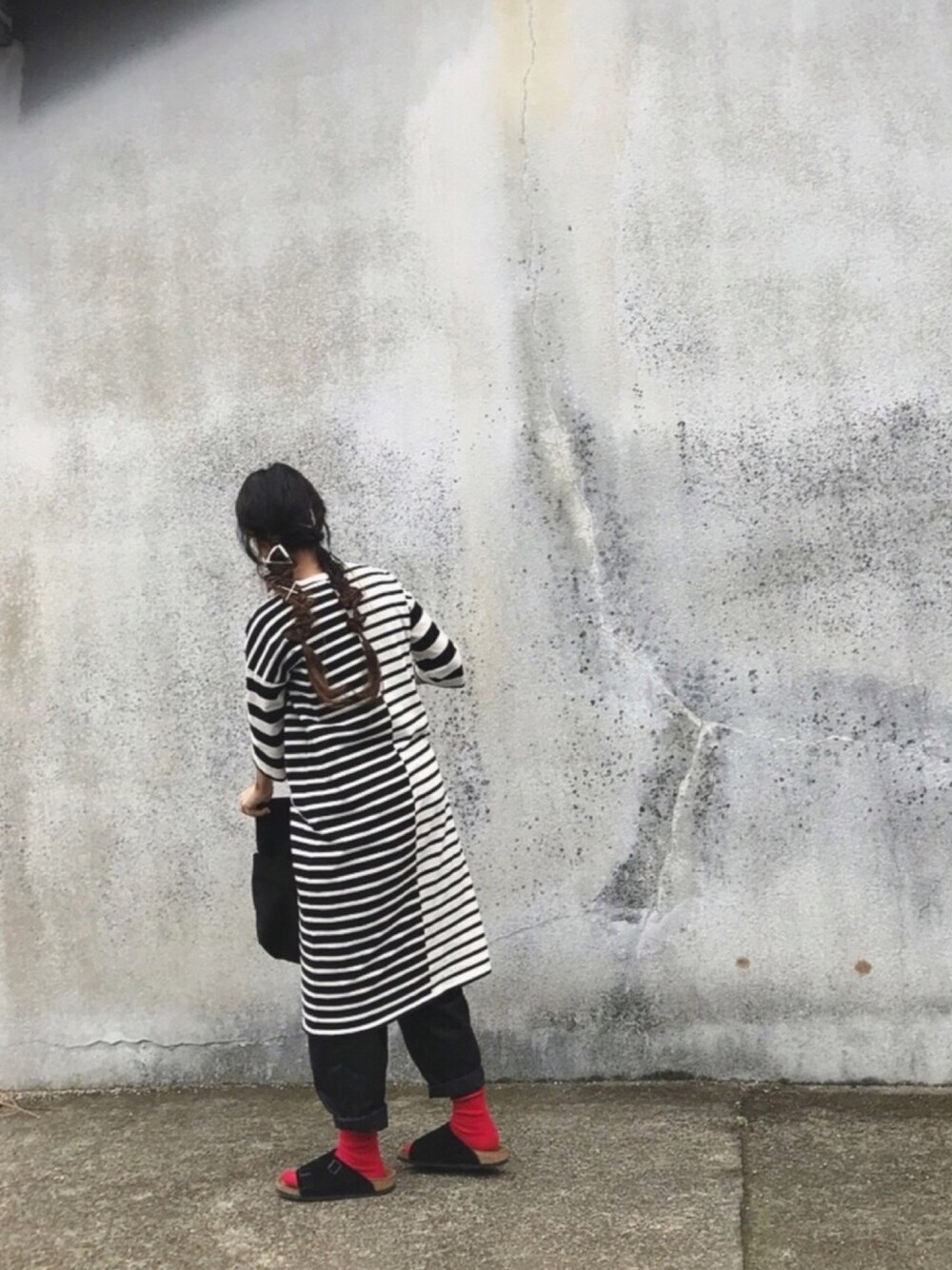 ホワイト系のワンピース、ブラック系のチノパンツ、ブラック系のサンダルを着用したレディースの春コーディネートの1枚目の写真