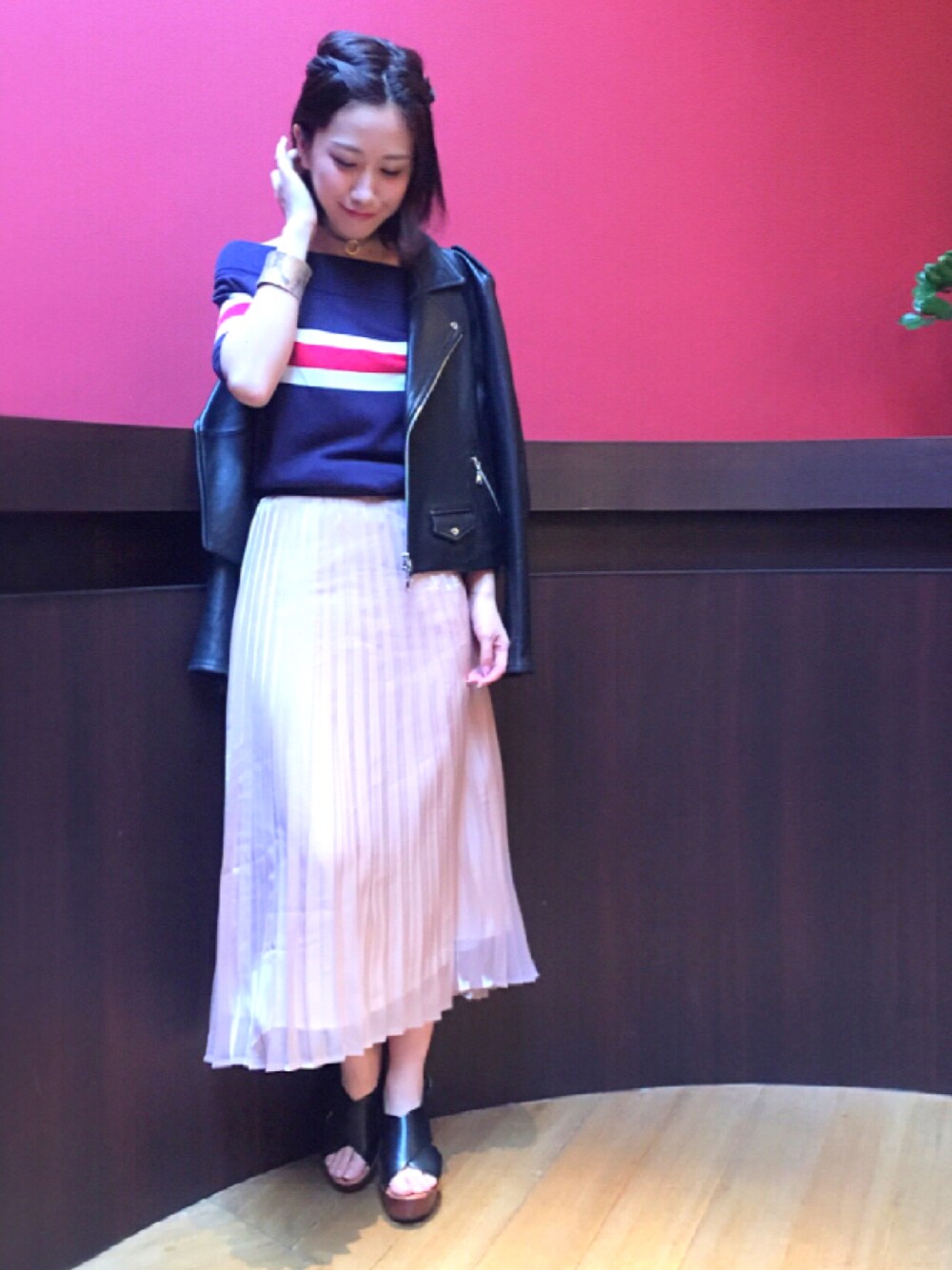 ブラック系のライダースジャケット、ブルー系のニット/セーター、ピンク系のスカートを着用したレディースの春コーディネートの1枚目の写真