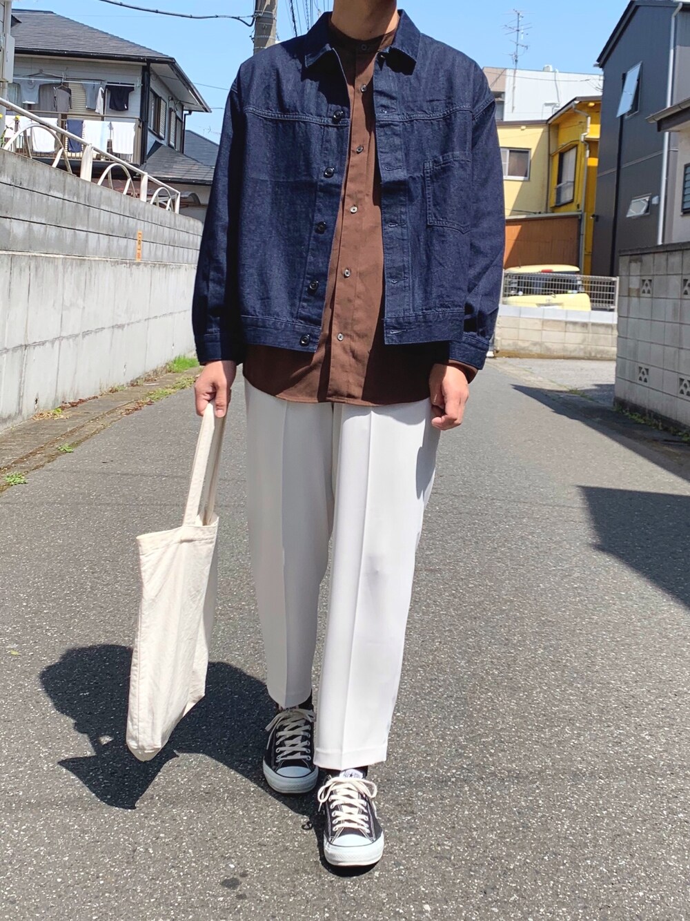 ブラック系のスニーカー、ブラウン系のシャツ/ブラウス、ブルー系のデニムジャケットを着用したメンズの春コーディネートの1枚目の写真