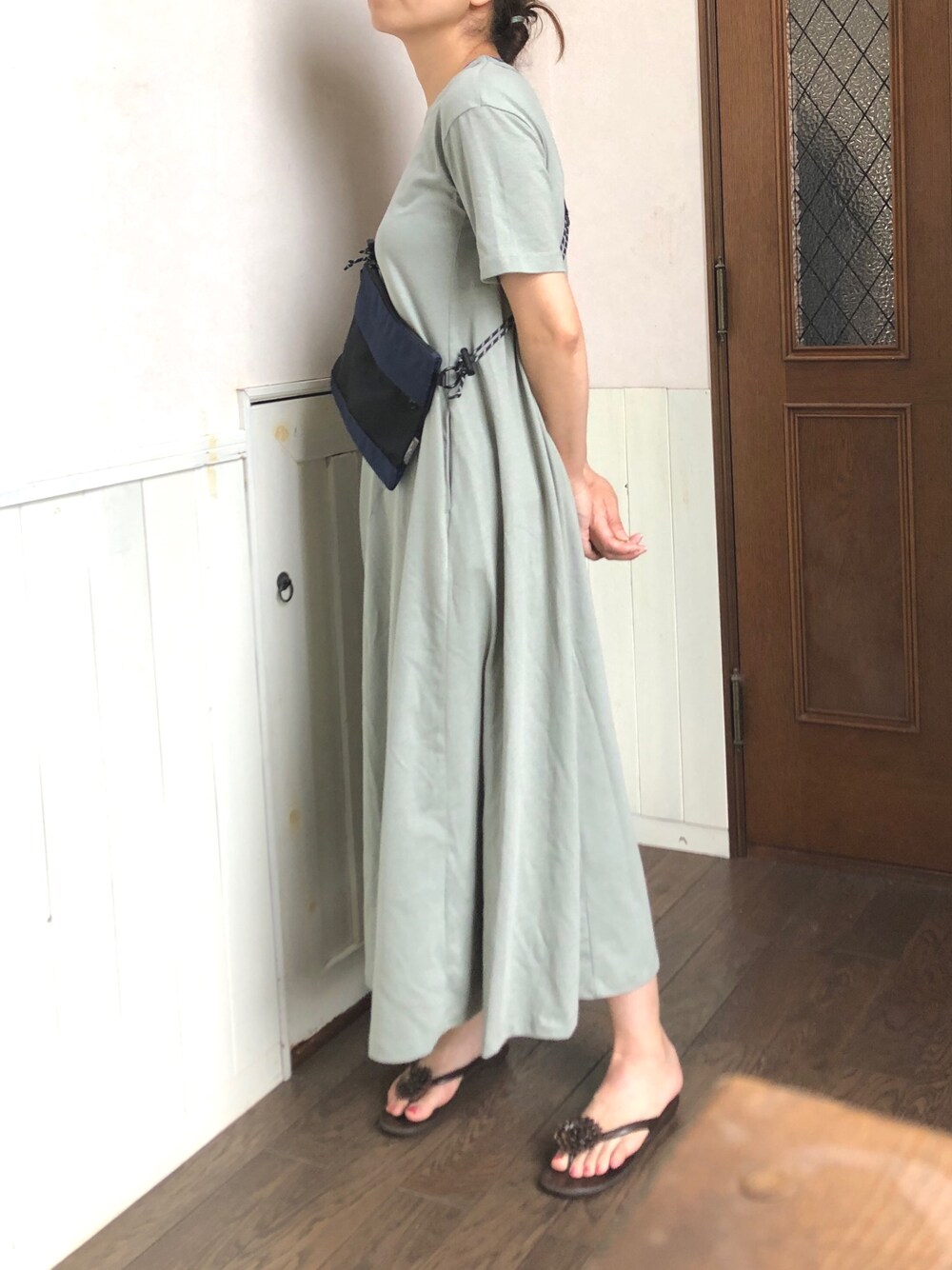グリーン系のワンピース、ブルー系のメッセンジャーバッグ、ブラウン系のサンダルを着用したレディースの夏コーディネートの1枚目の写真