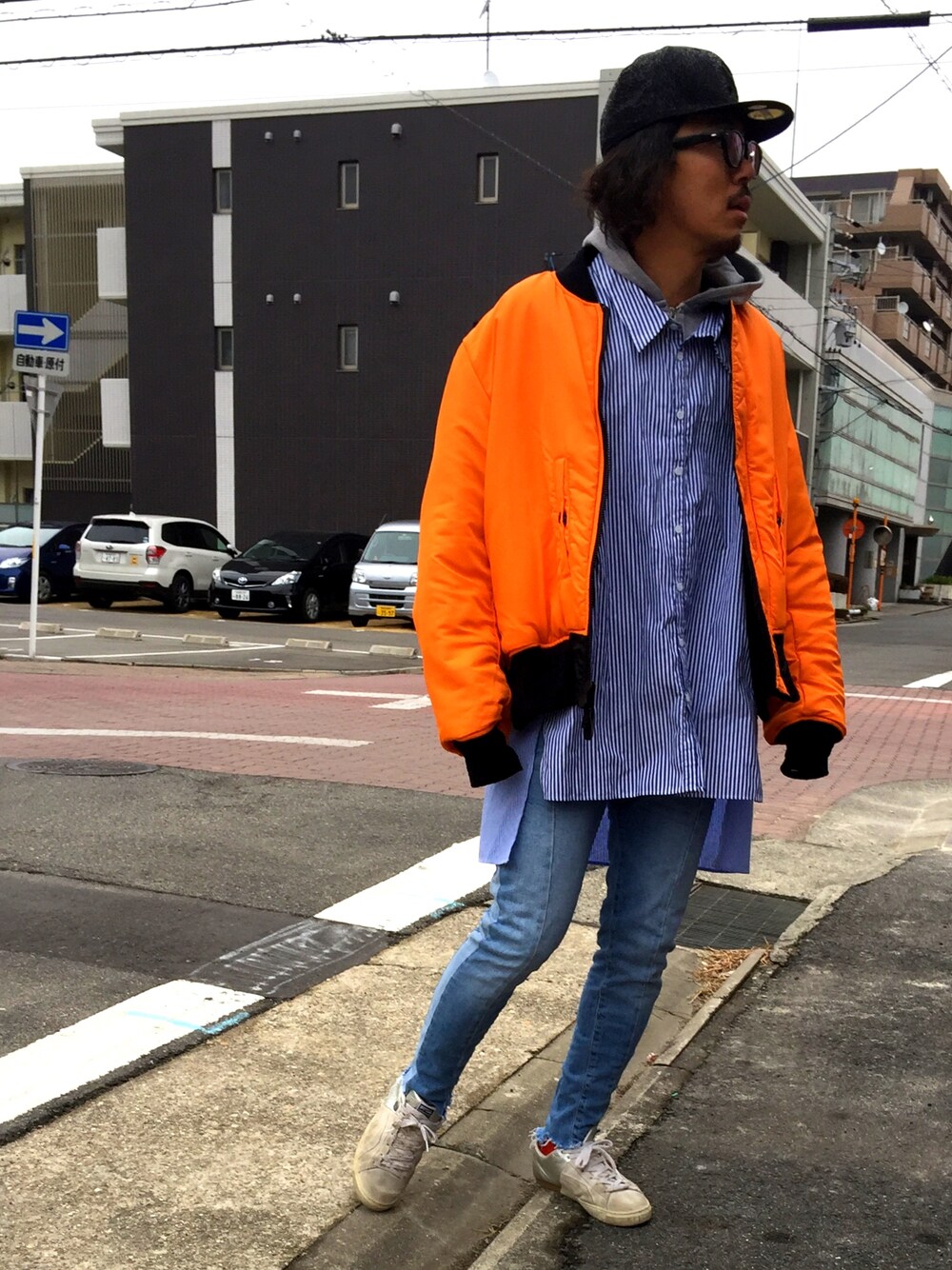 ホワイト系のスニーカー、ブラック系のMA-1、ブラック系のキャップを着用したメンズの冬コーディネートの1枚目の写真