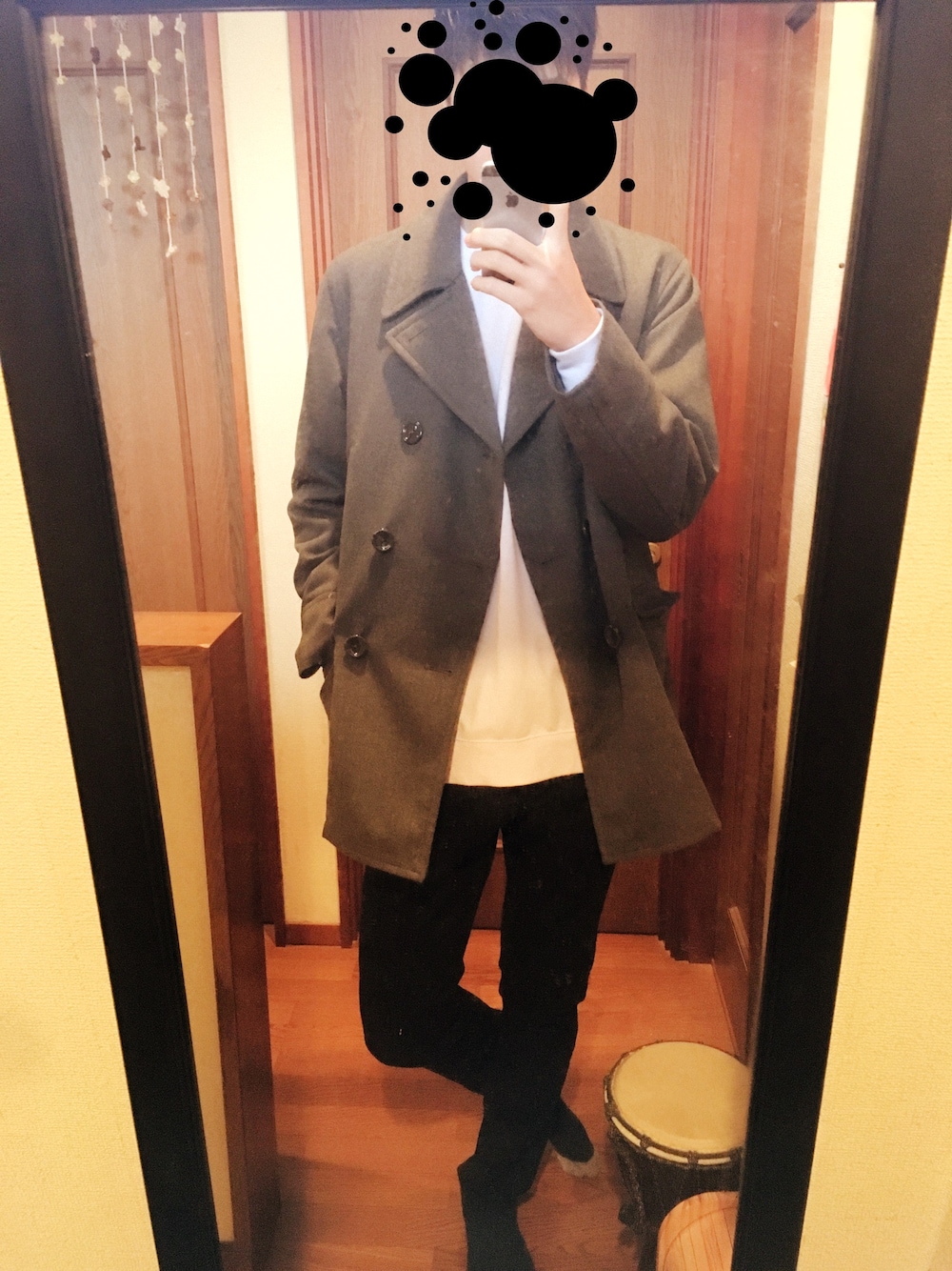 ブラック系のデニムパンツ、ホワイト系のスウェット、グレー系のピーコートを着用したメンズの春コーディネートの1枚目の写真