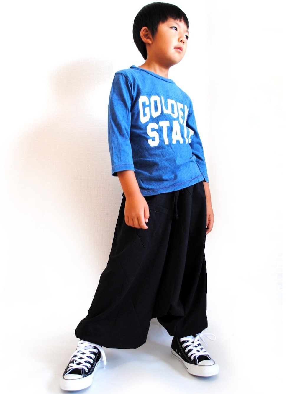 ブラック系のパンツ、ブルー系のTシャツ/カットソー、ブラック系のスニーカーを着用したレディースの秋コーディネートの1枚目の写真