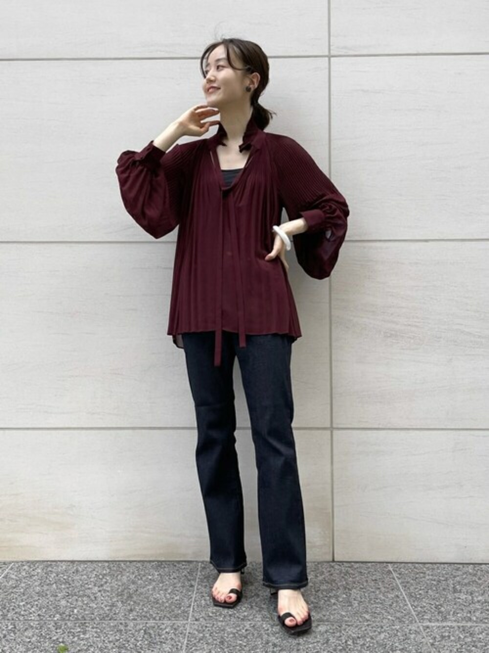 ブルー系のデニムパンツ、ブラウン系のサンダル、ホワイト系のバングル/リストバンドを着用したレディースの夏コーディネートの1枚目の写真