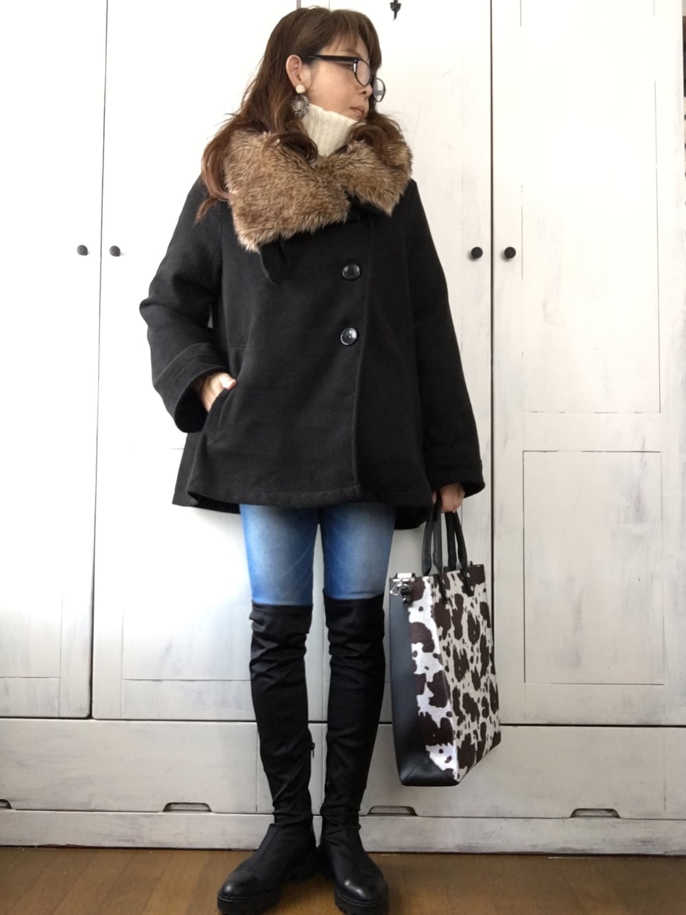 ブラック系のピーコート、ブラウン系のトートバッグ、ブラック系のブーツを着用したレディースの冬コーディネートの1枚目の写真