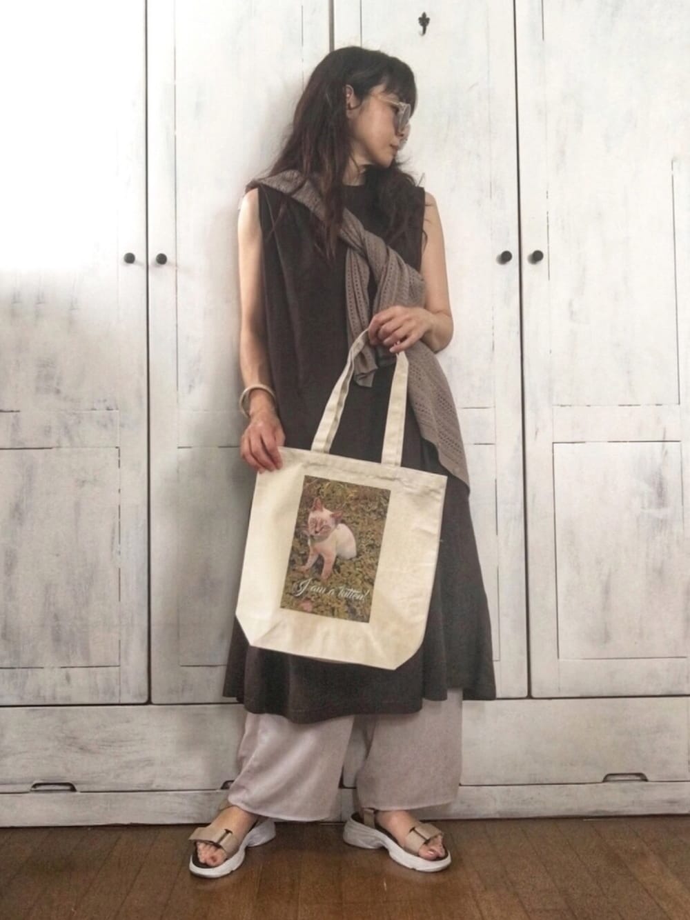 ベージュ系のトートバッグ、ベージュ系のニット/セーター、グレー系のワンピース/ドレスを着用したレディースの夏コーディネートの1枚目の写真