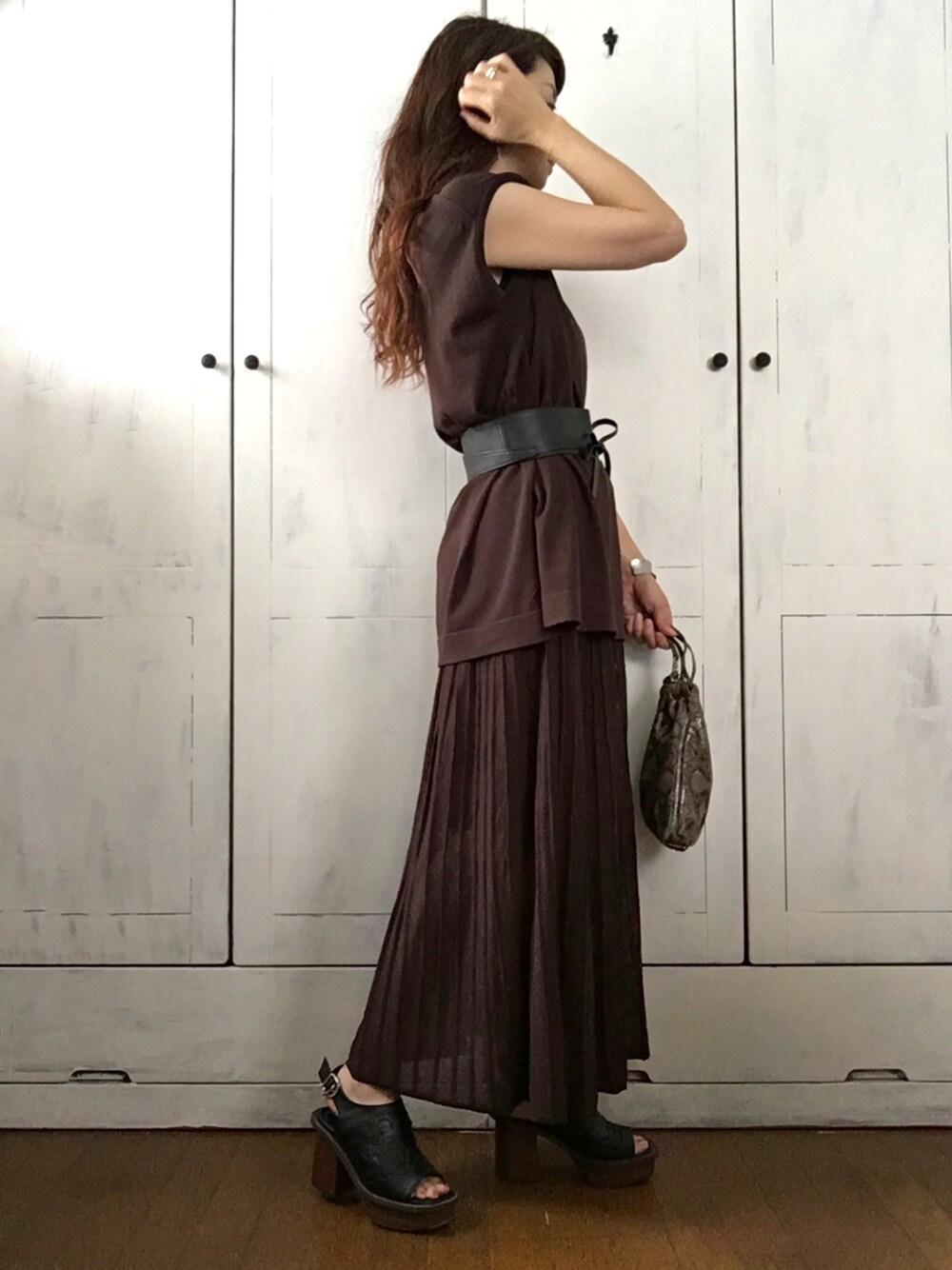 ブラウン系のニット/セーター、ブラウン系のスカート、ブラウン系のショルダーバッグを着用したレディースの夏コーディネートの1枚目の写真